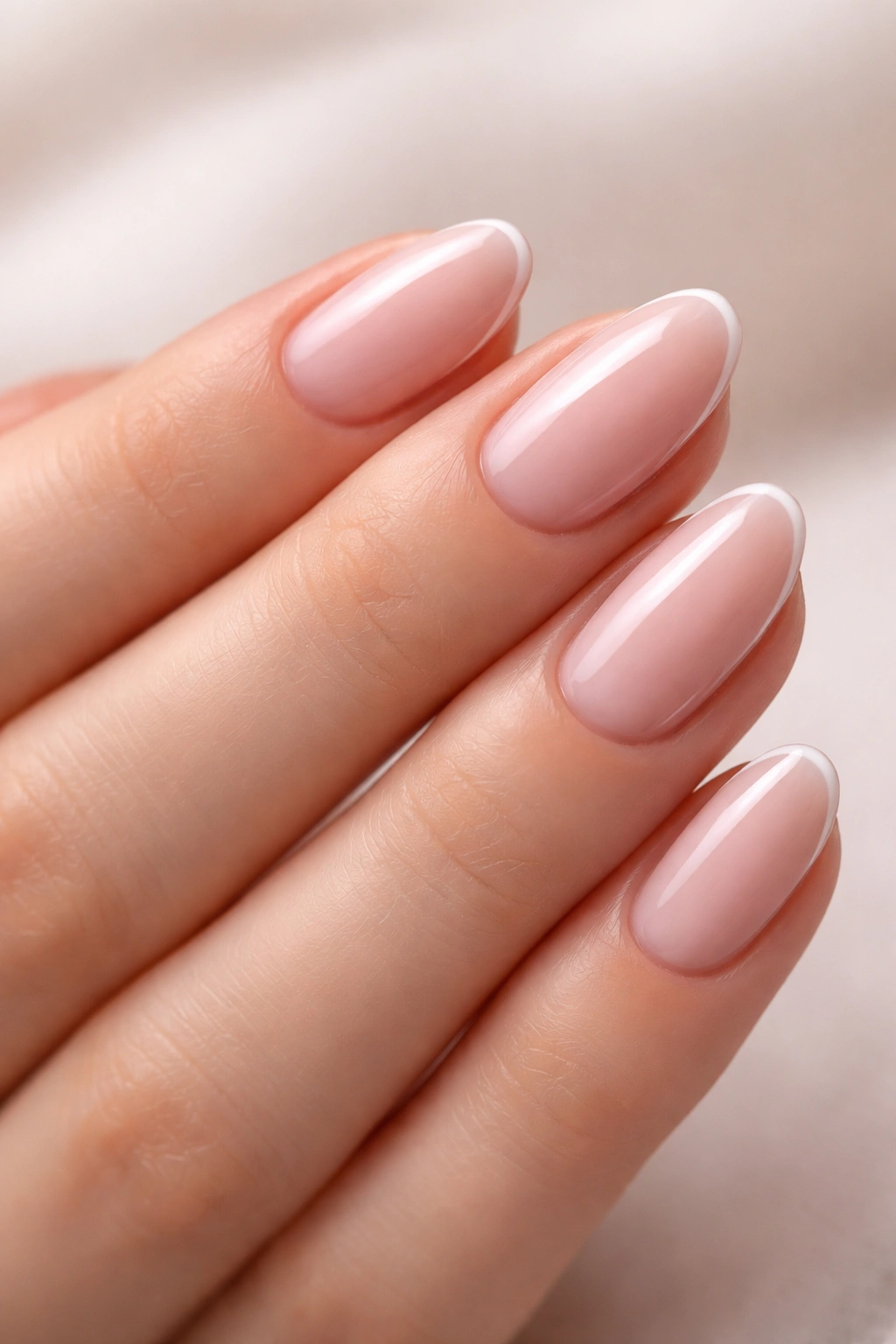 Nails in milky pink with a thin white accent line.