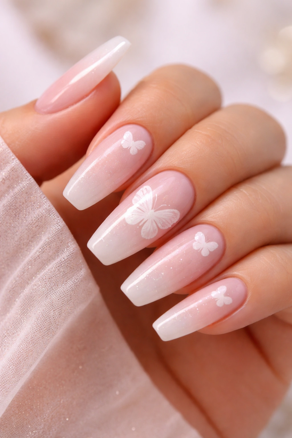 Nails with milky pink base and floating white butterfly decals.