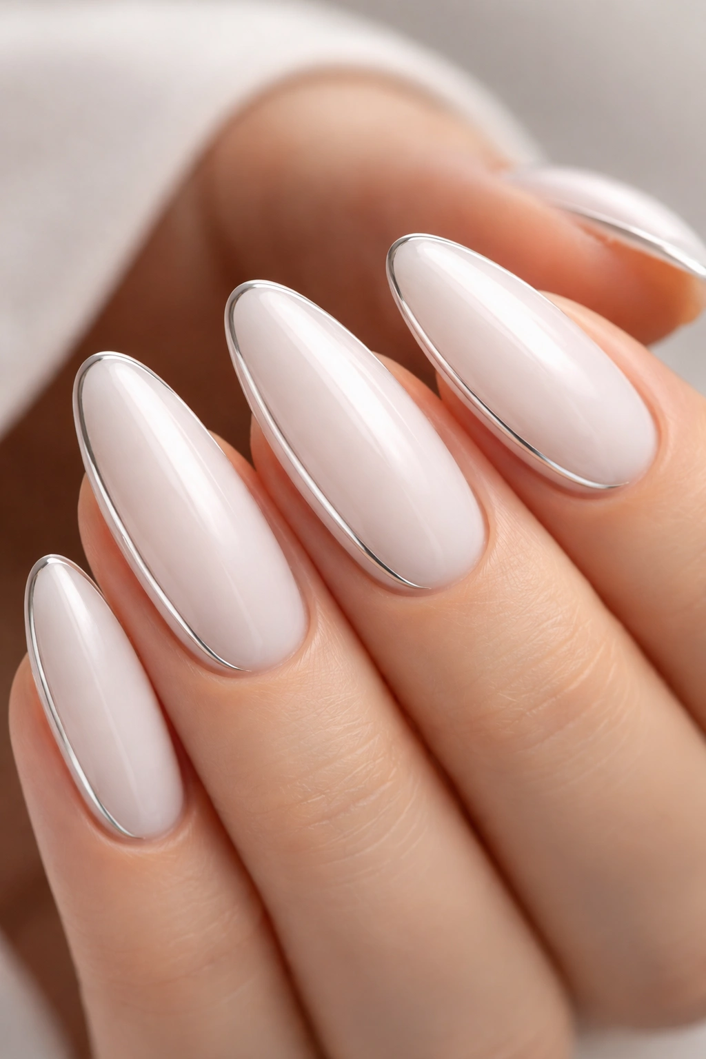 Close-up of nails with milky white glaze and thin chrome side line