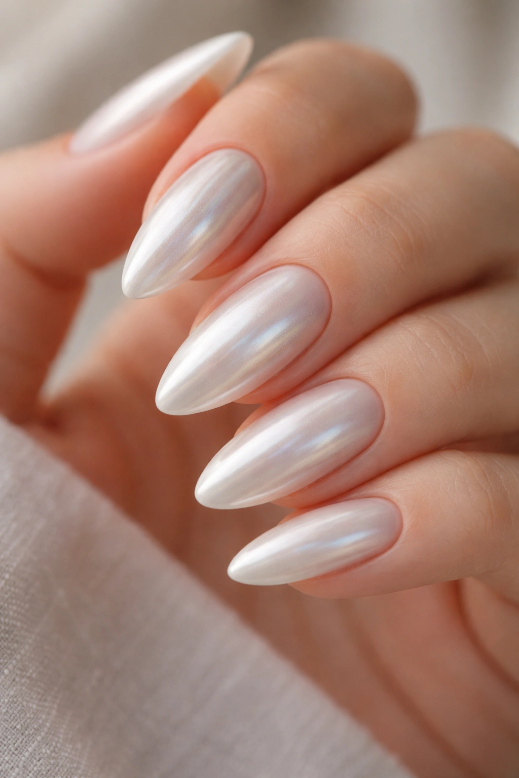 Almond nails with milky base and subtle chrome pearlescent sheen