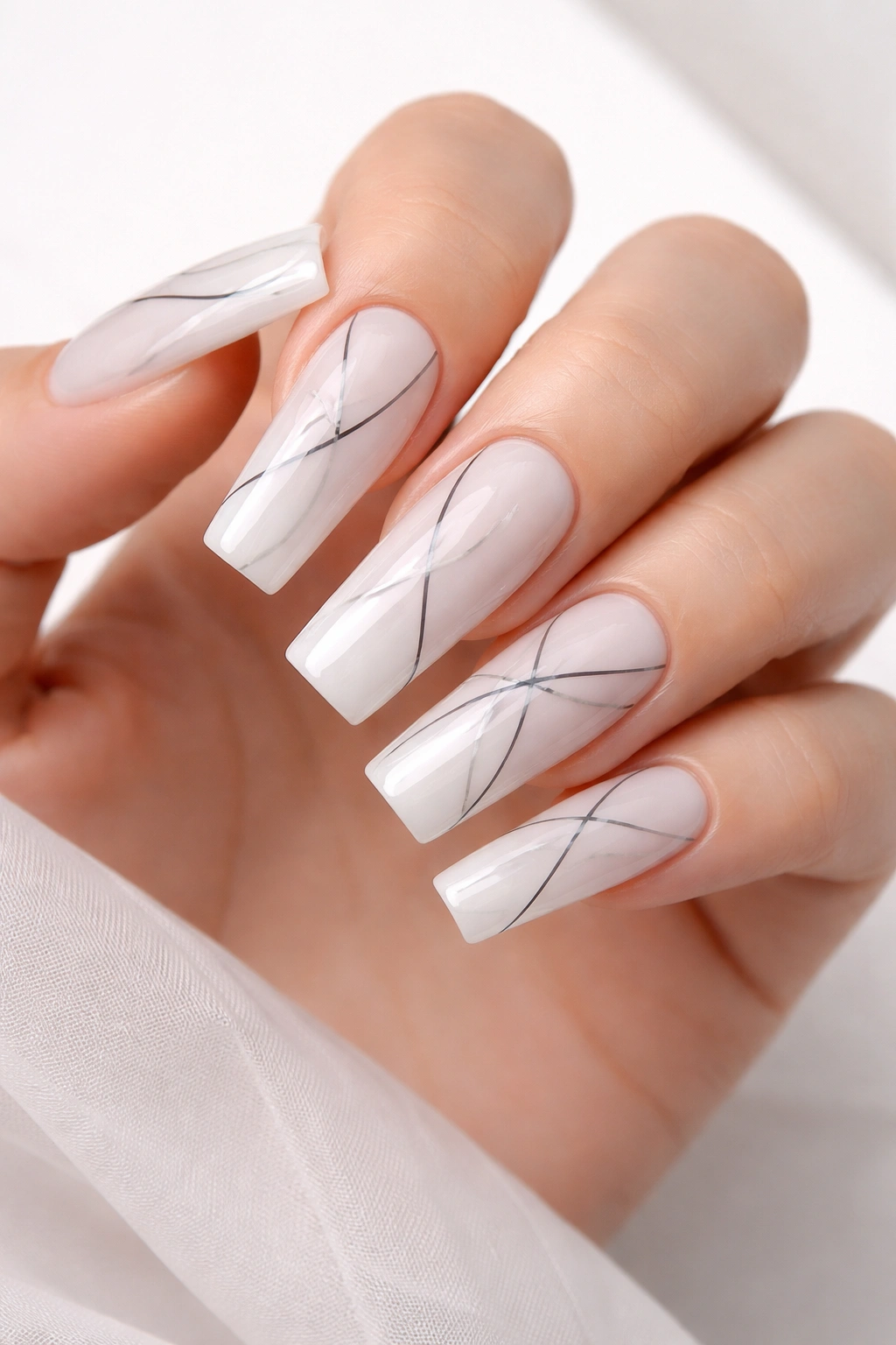 Milky white nails with abstract black lines on long square acrylics.