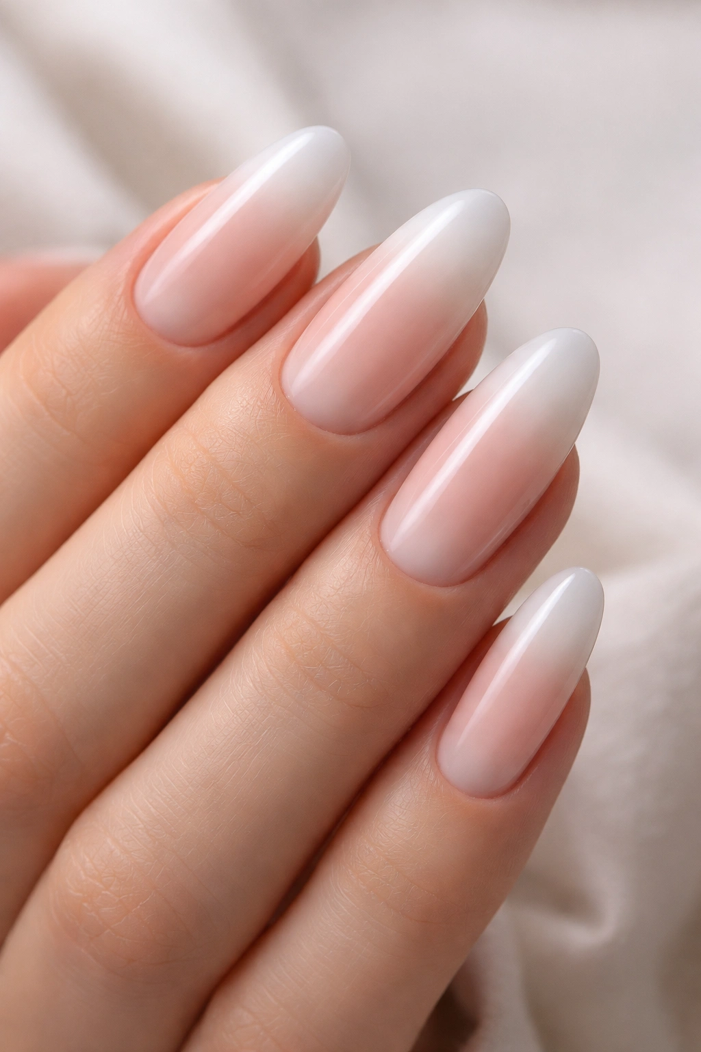 Milky white nails with translucent blush tips on long oval shape