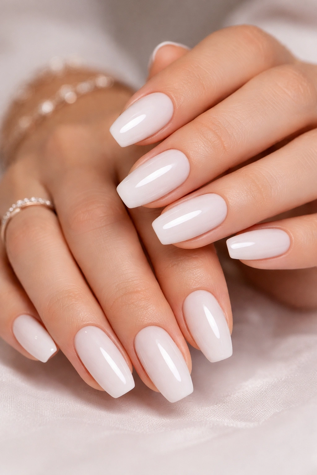 Close-up of milky white nails with high-gloss finish