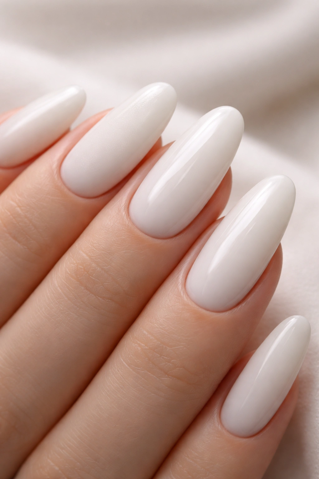 Close-up of milky white long oval nails with alternating matte and glossy finishes
