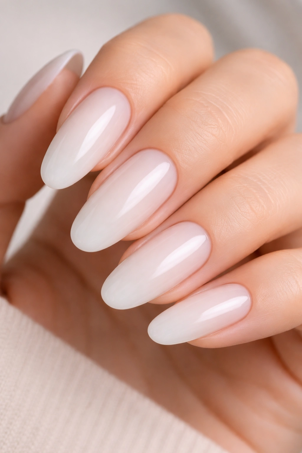 Milky white nail with soft ombre gradient on long oval nail