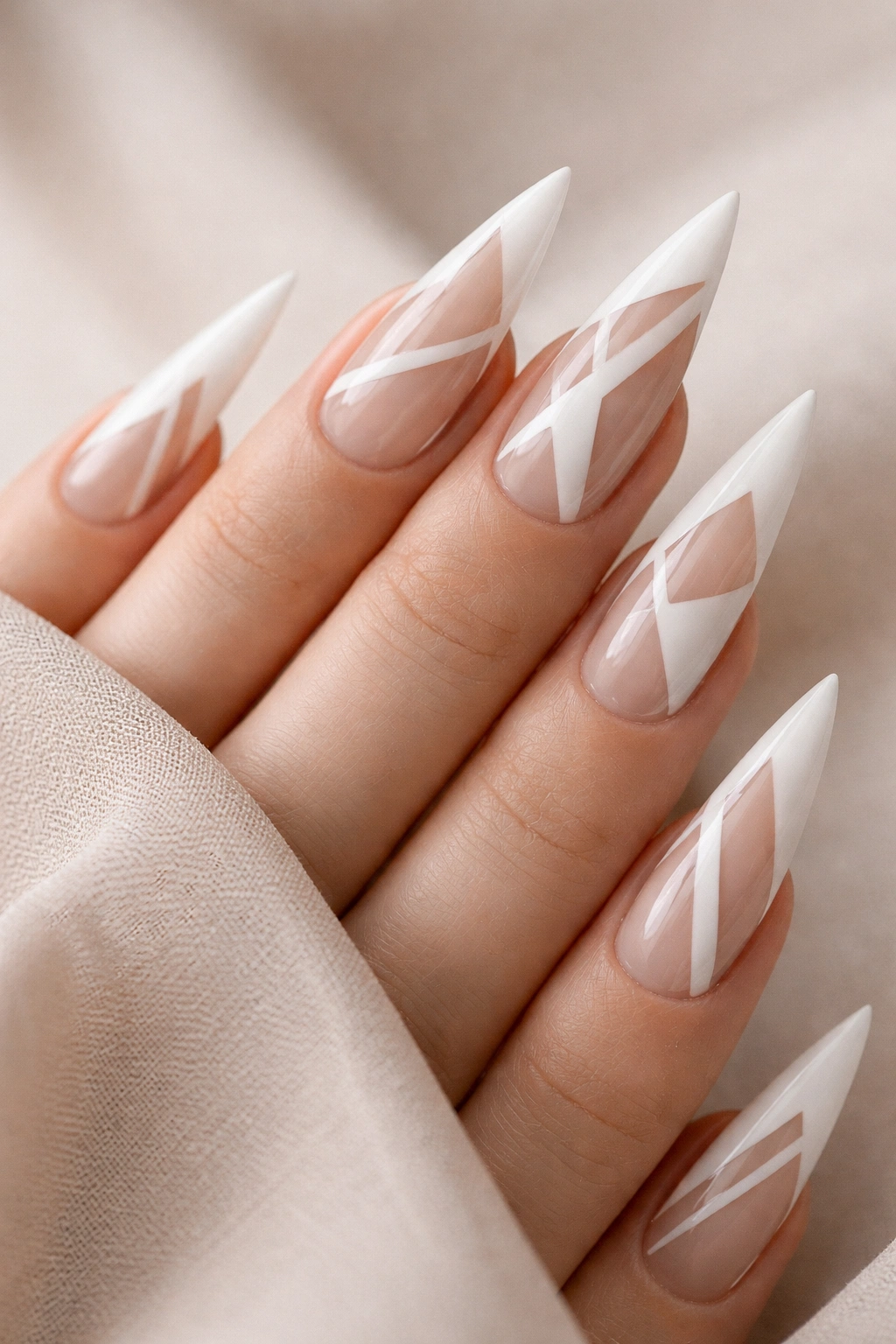 Milky white stiletto nails with bold negative-space geometric designs