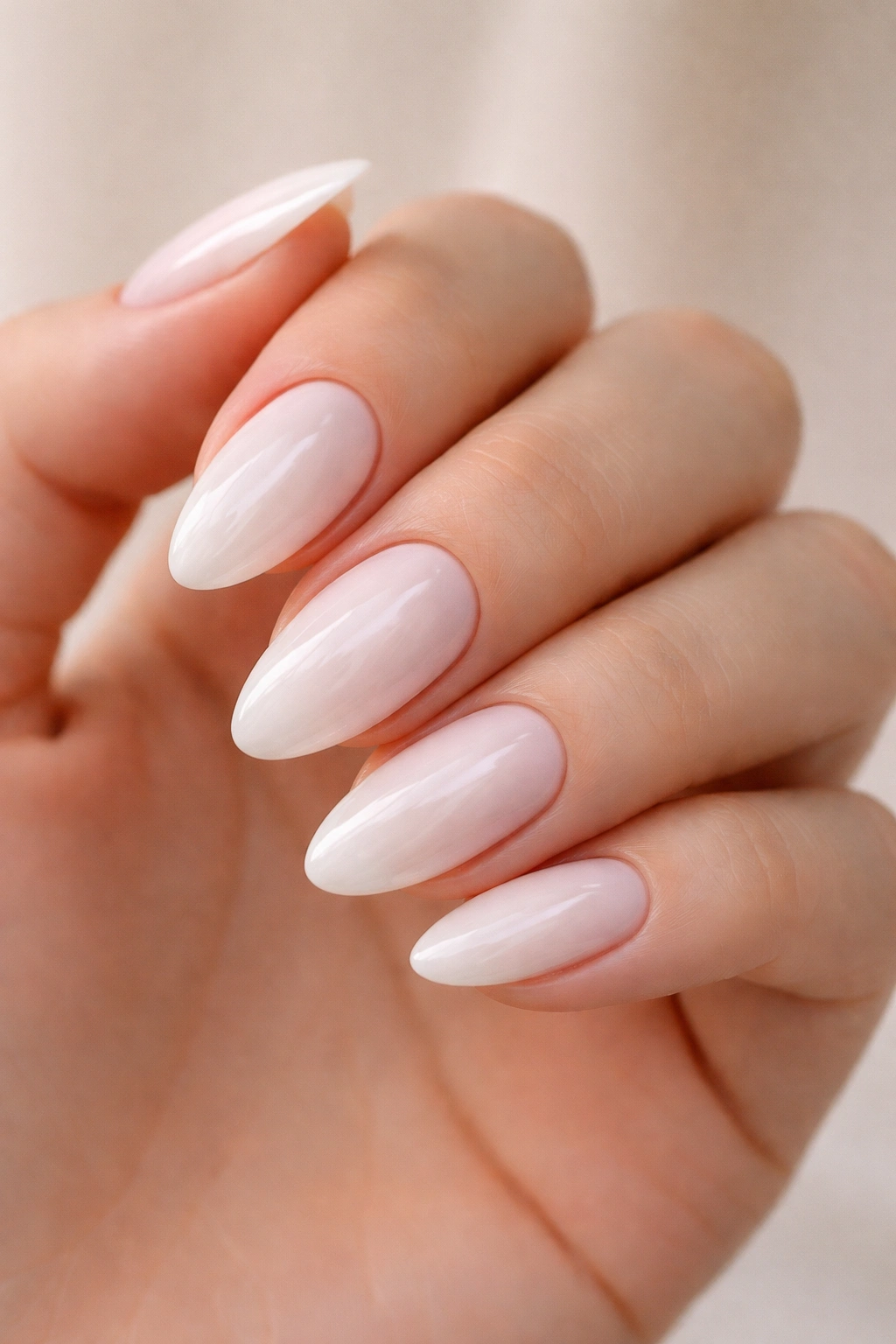 Almond nails with milky base and barely-there pink underlay under glossy top coat