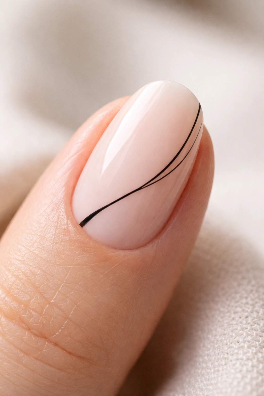 Close-up of a short oval nail with a thin black line