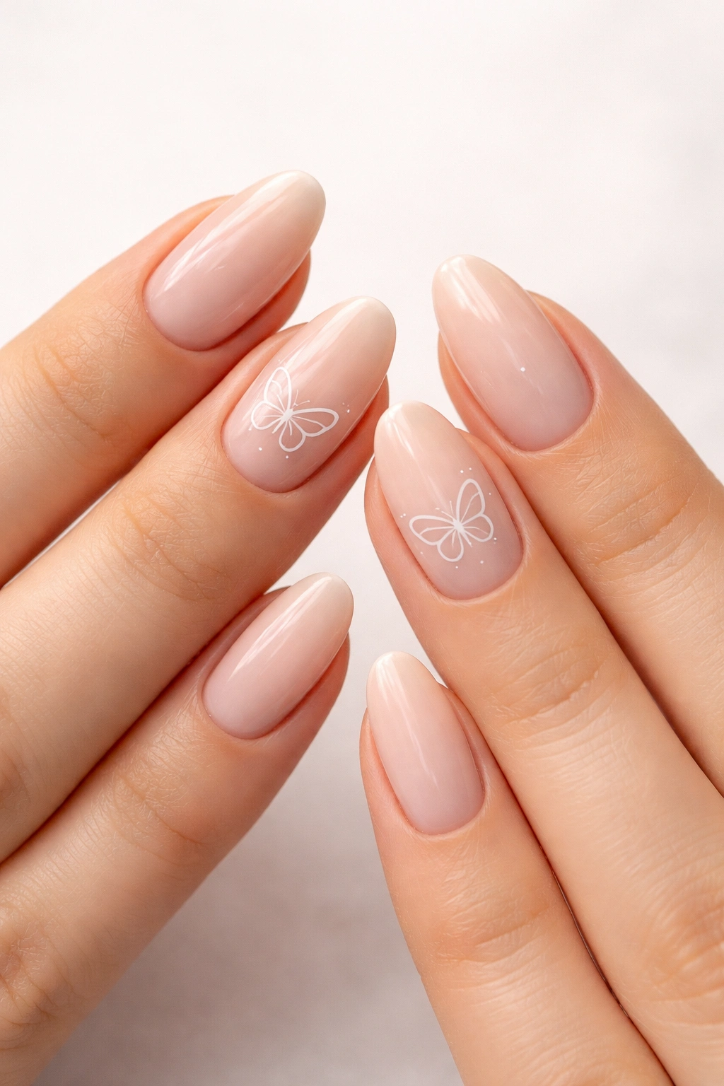 Close-up of minimalist butterfly outline nails on nude bases