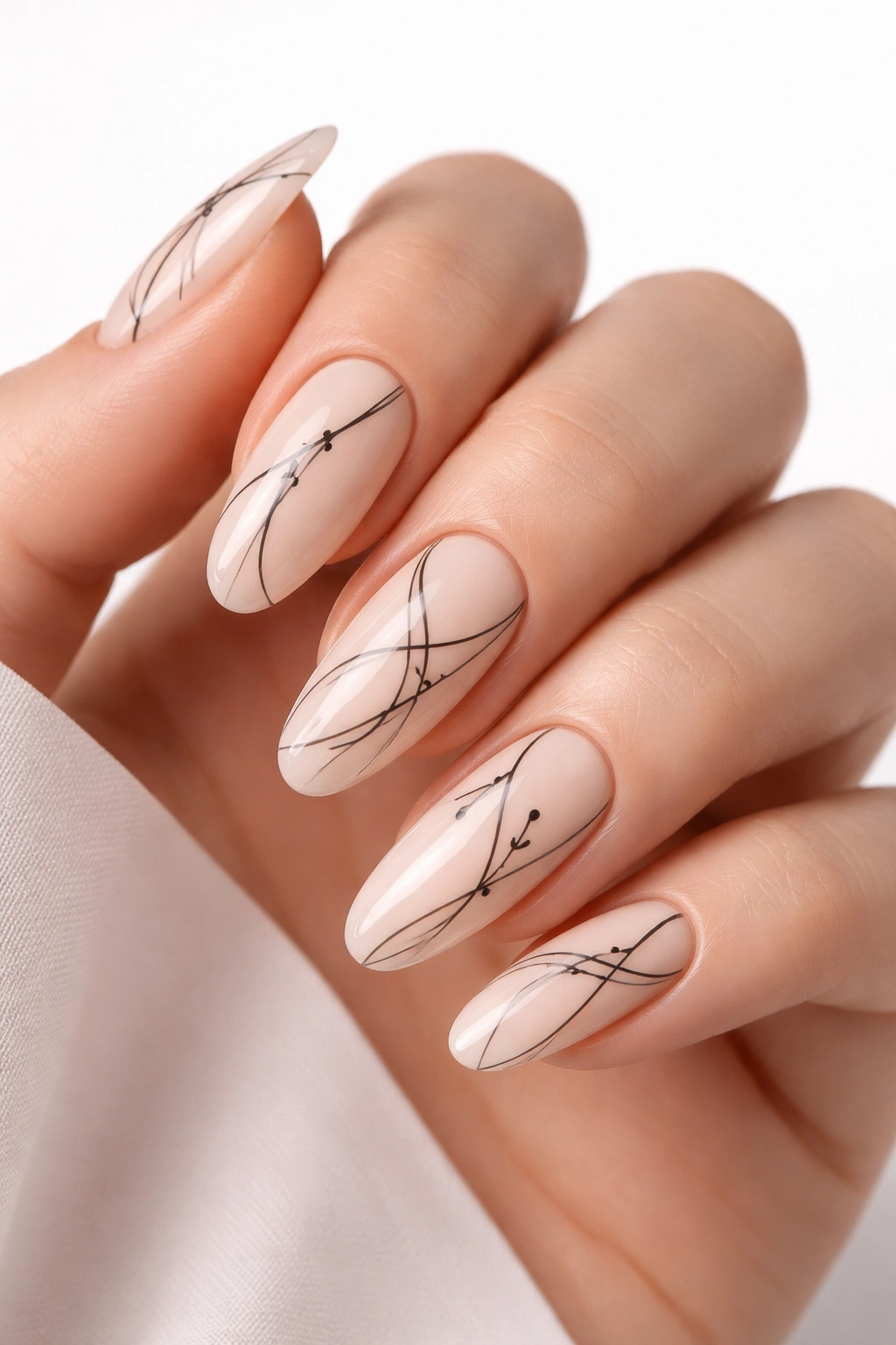 Close-up of long oval nails with ultra-thin black line art on nude base.