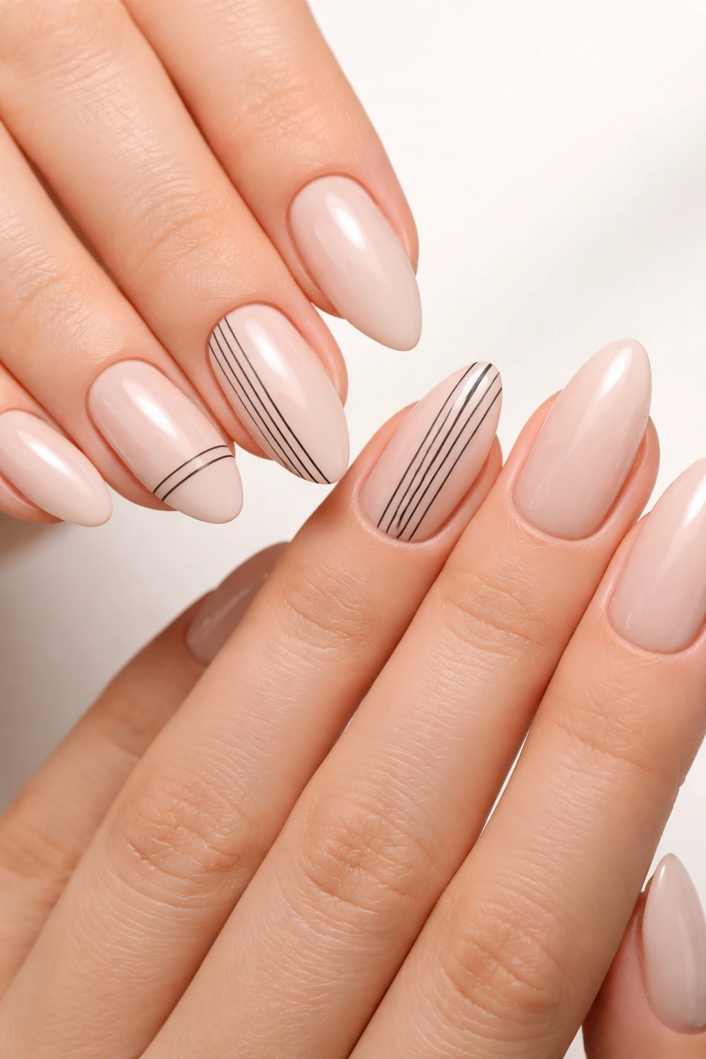 Close-up of minimalist line art on almond nails on two hands