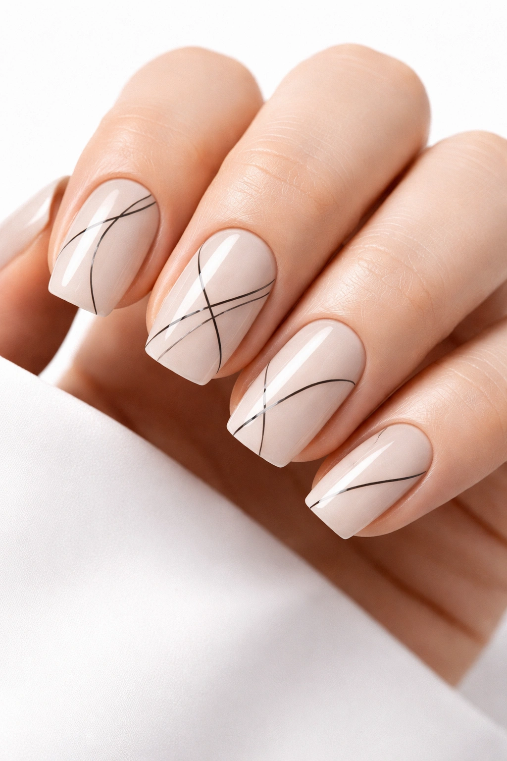 Nude nails with delicate black lines and ample negative space