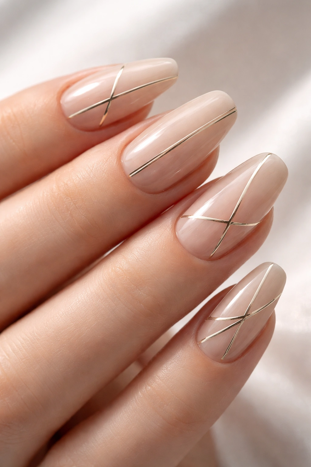 Nails with thin metallic line accents on a nude base
