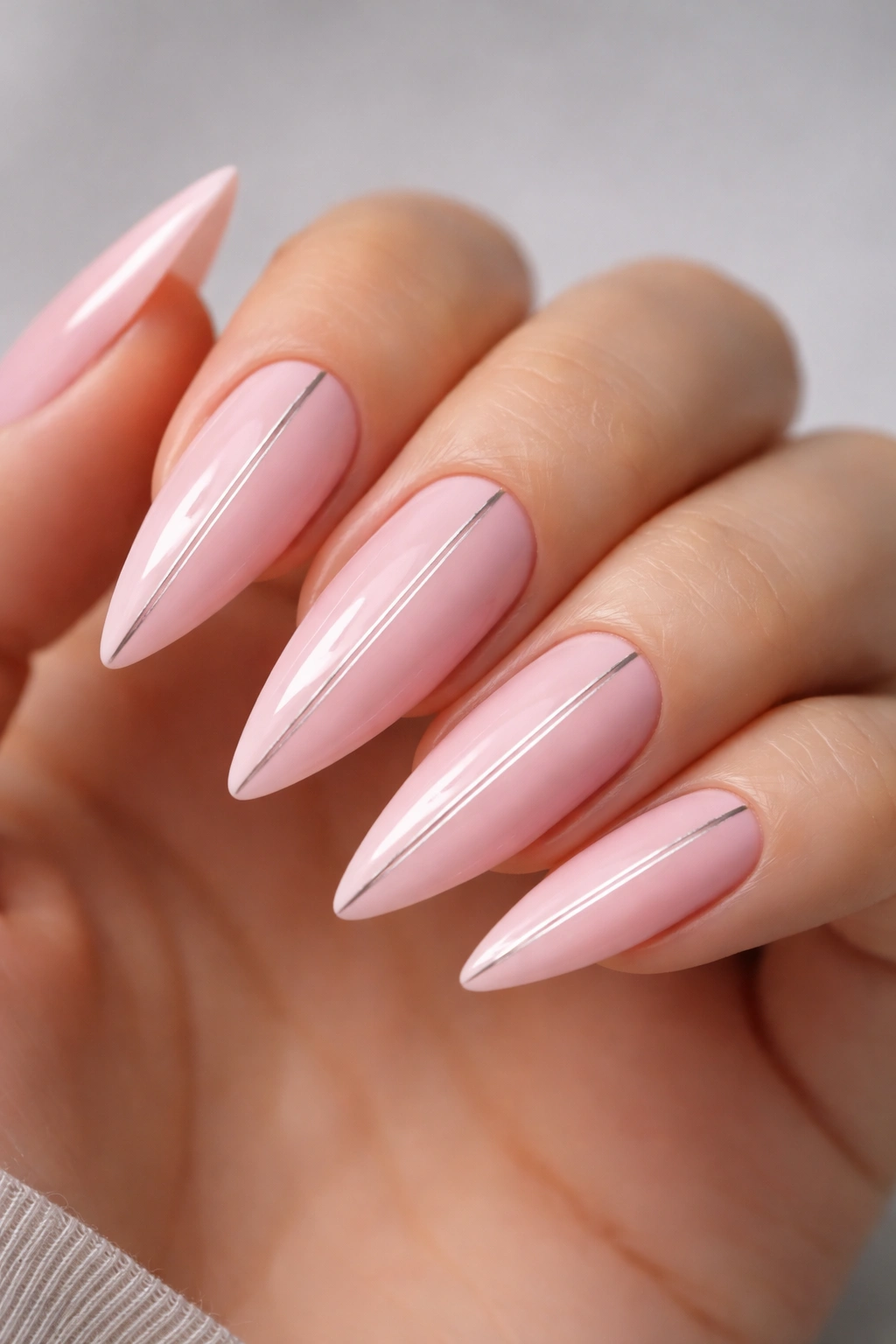 Close-up of minimalist baby pink nails with a single accent line