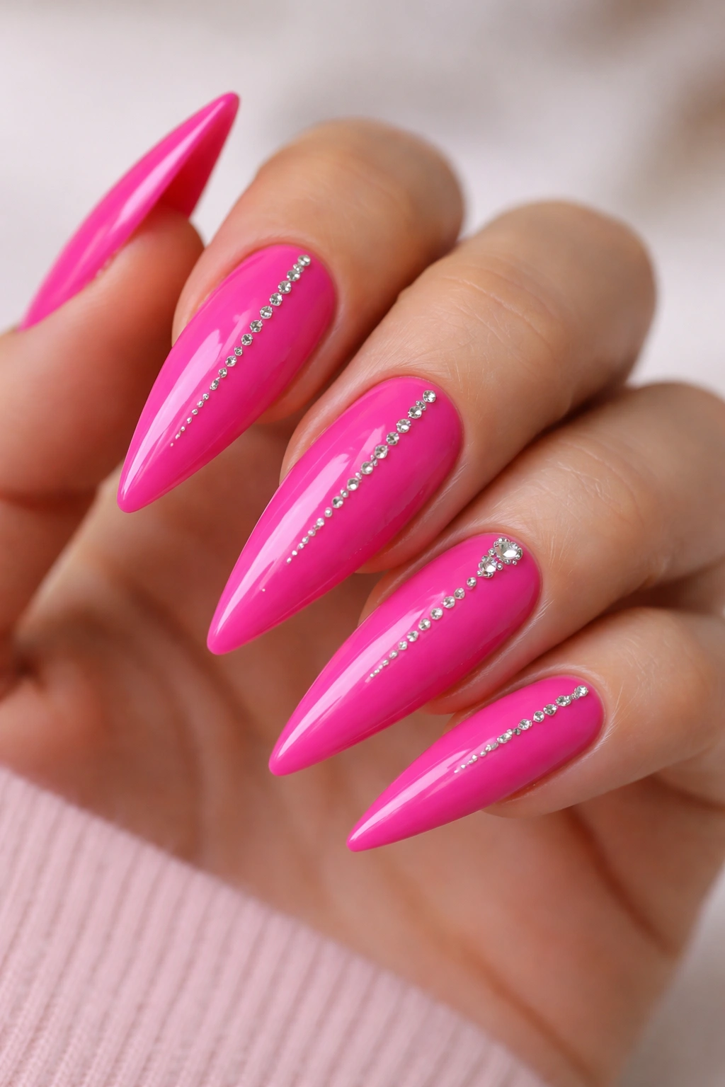 Minimalist hot pink nails with a single row of rhinestones