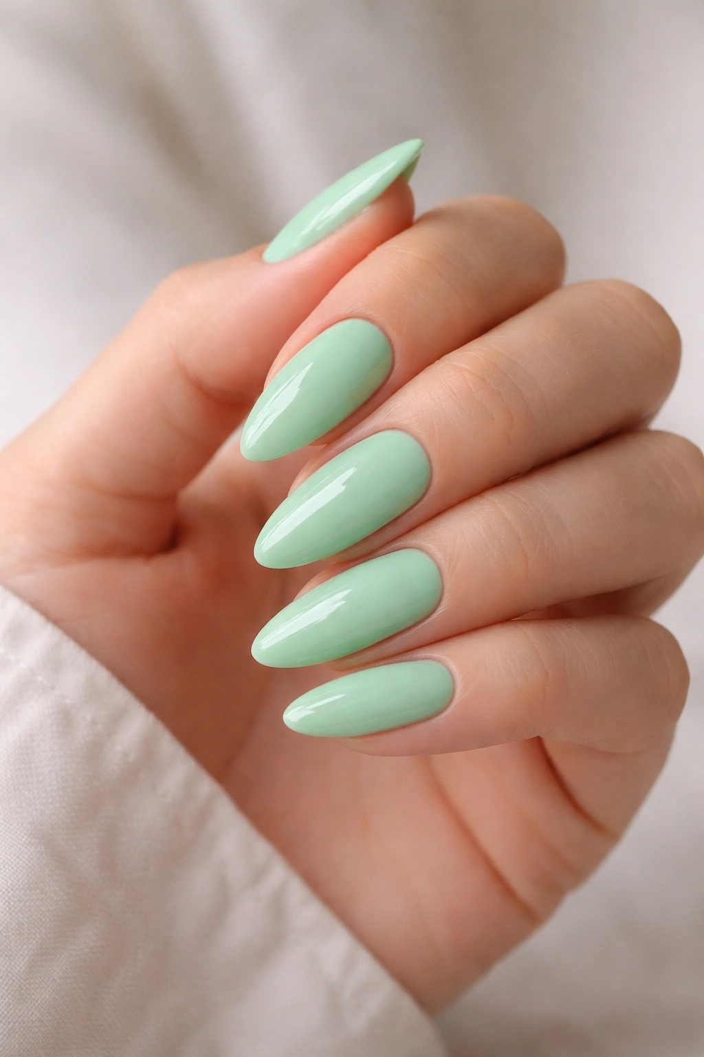 Mint green almond nails with glossy cream finish
