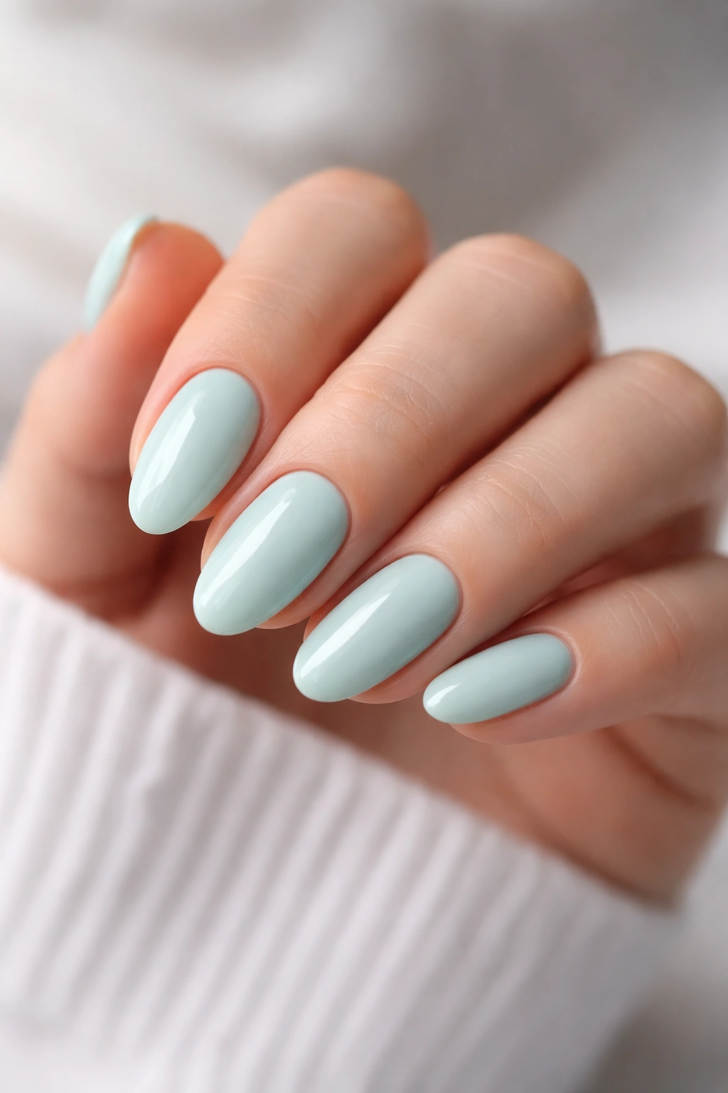 Close-up of pale mint almond nails on a hand