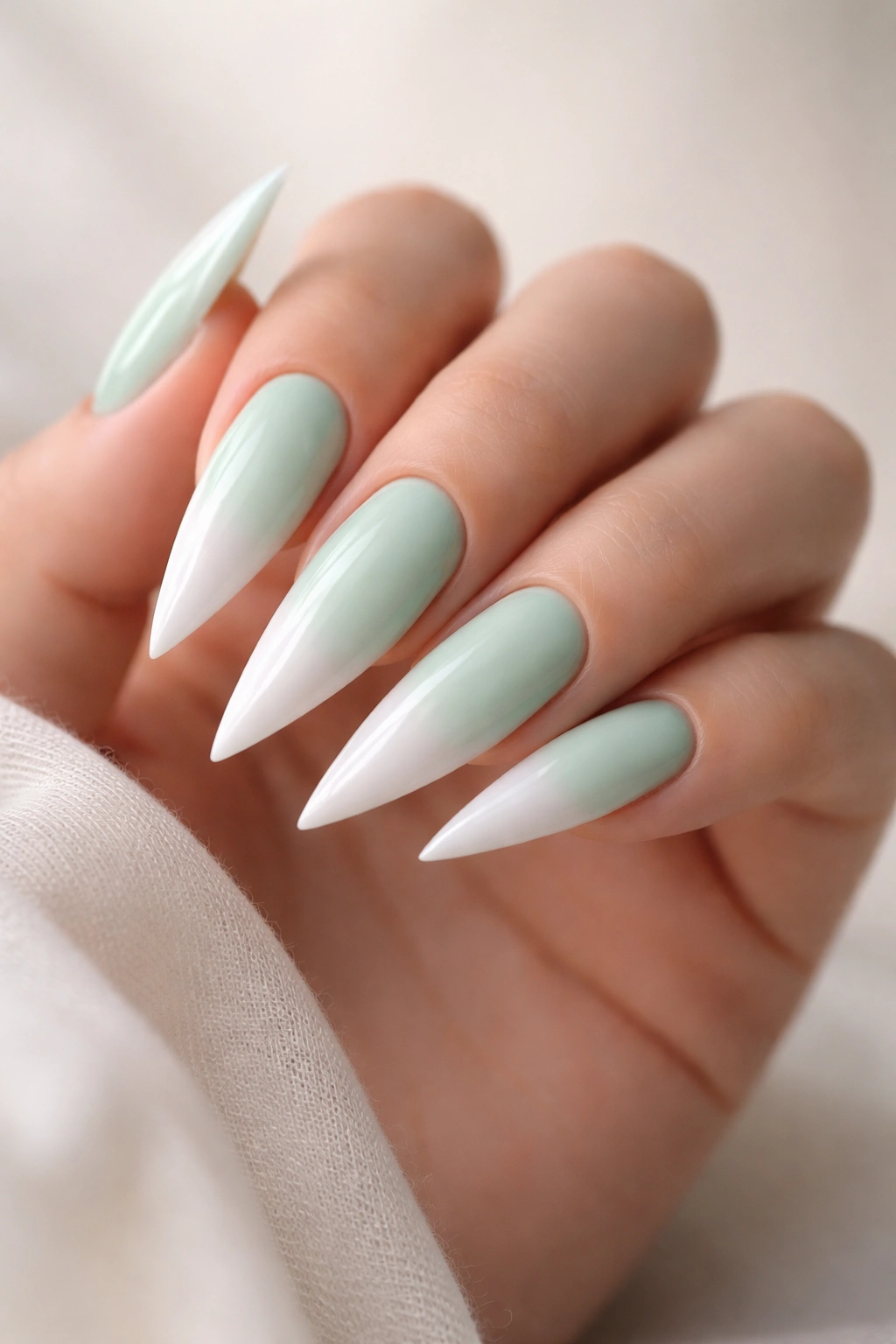 Mint green stiletto nails with white ombre tips close-up