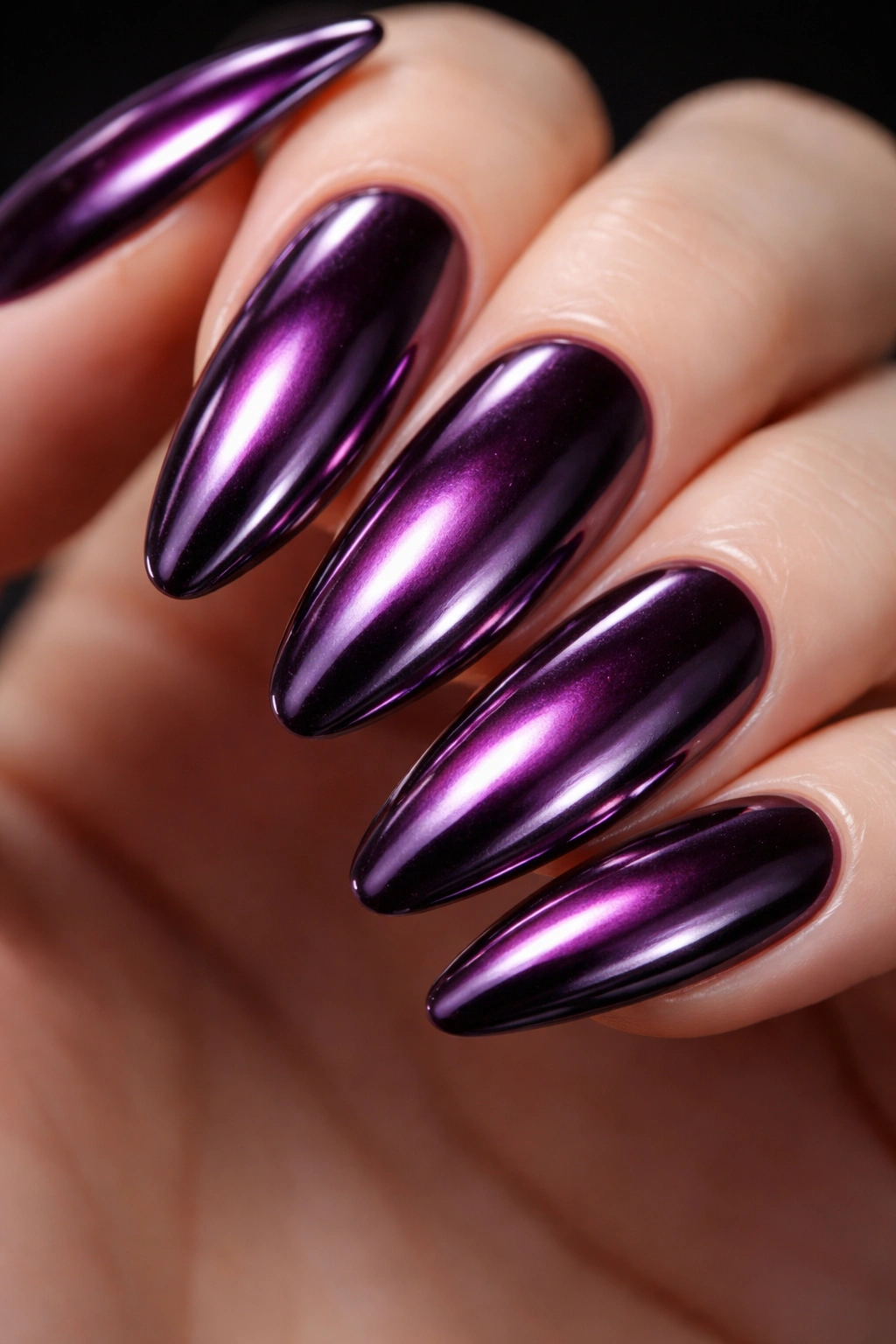 Close-up of deep plum nails with a silver mirror chrome finish reflecting light