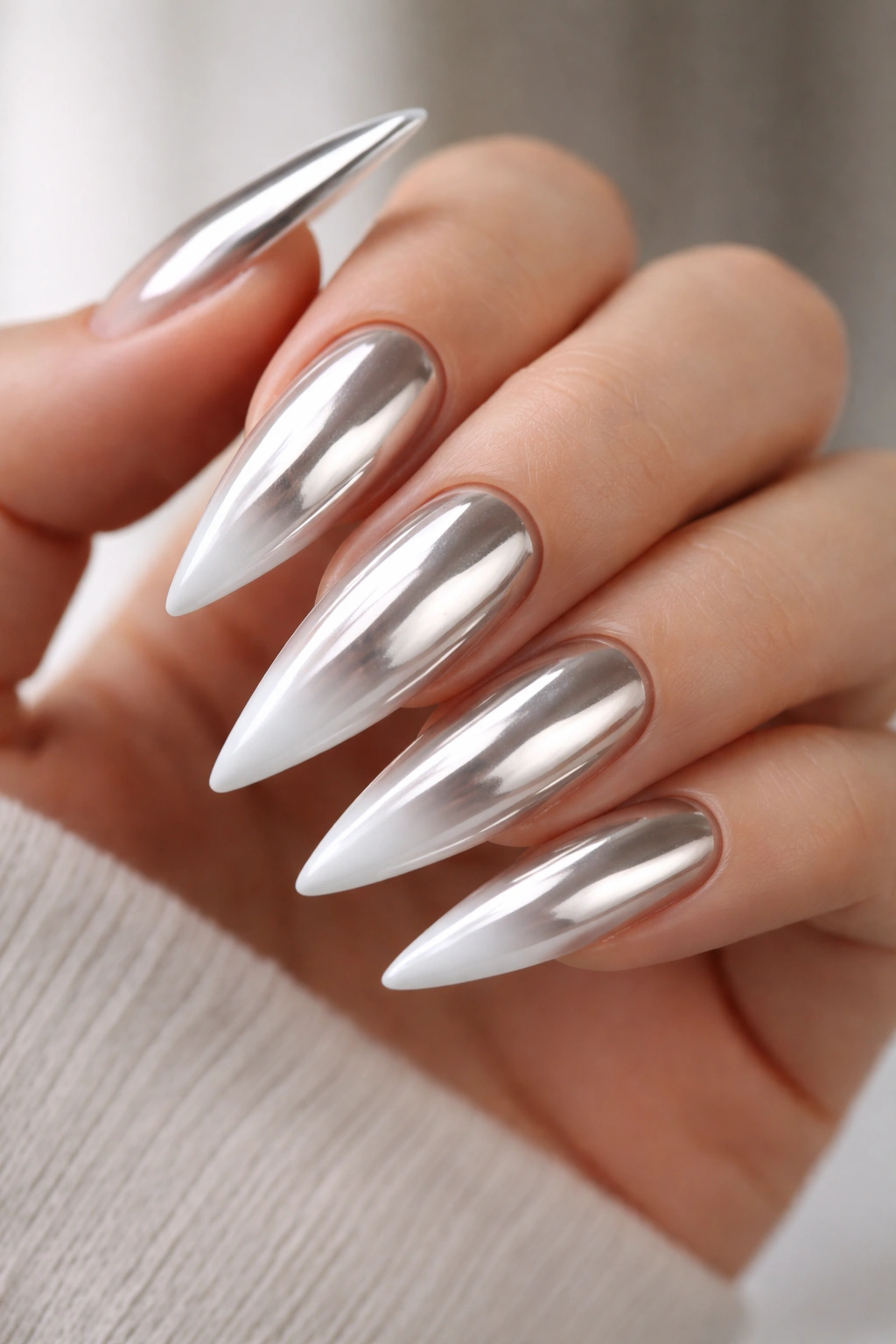 Close-up of mirror chrome nails with nude-to-white ombre tips
