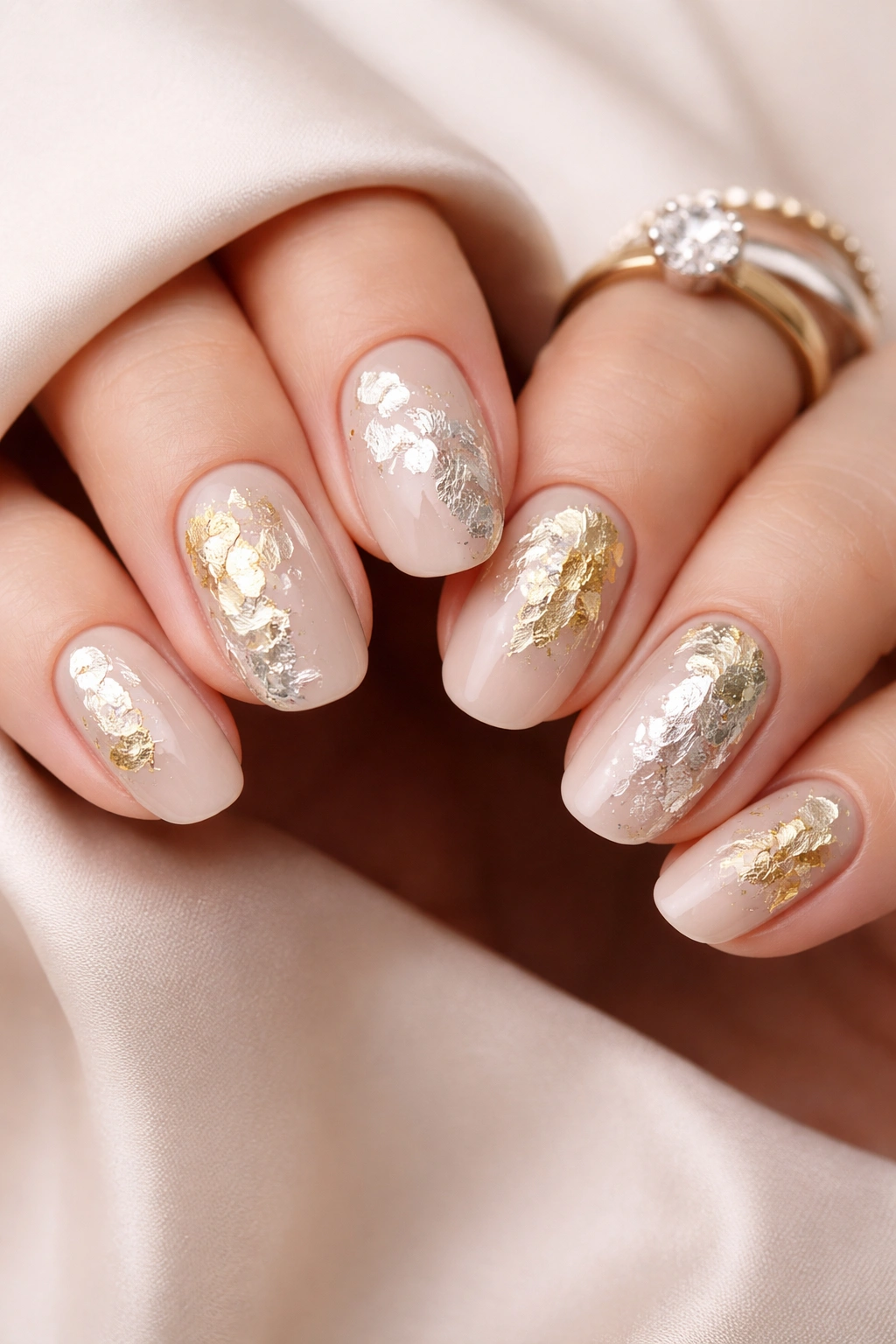 Close-up of nails with gold and silver foil accents