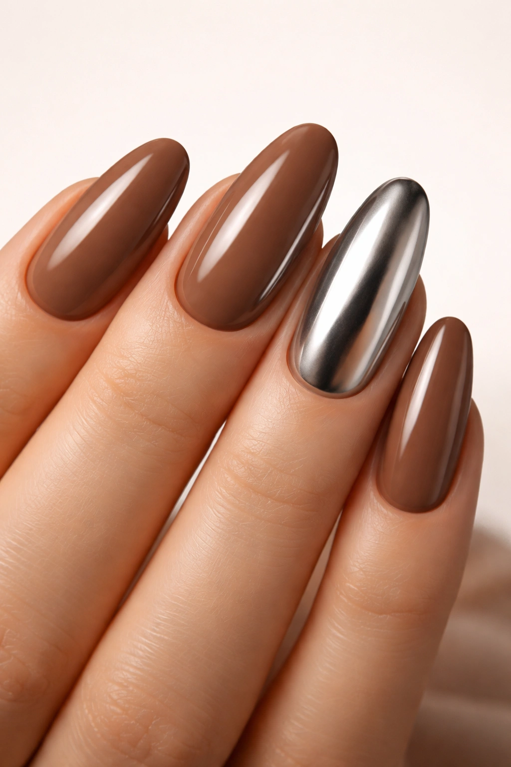 Mocha nails with a chrome accent nail on the ring finger
