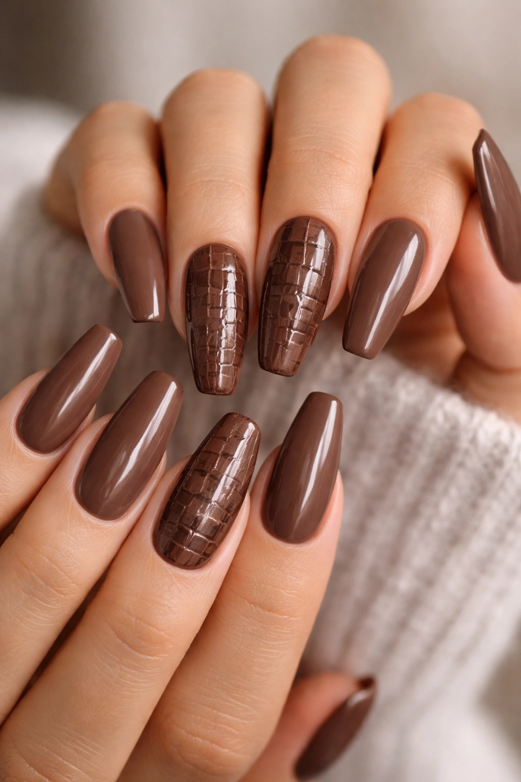Close-up of mocha brown nails with croc texture on accent nails against a neutral backdrop.