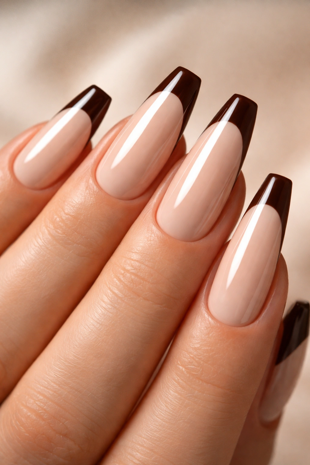 Close-up of mocha milk nails with glossy cocoa tips and sharp tip line
