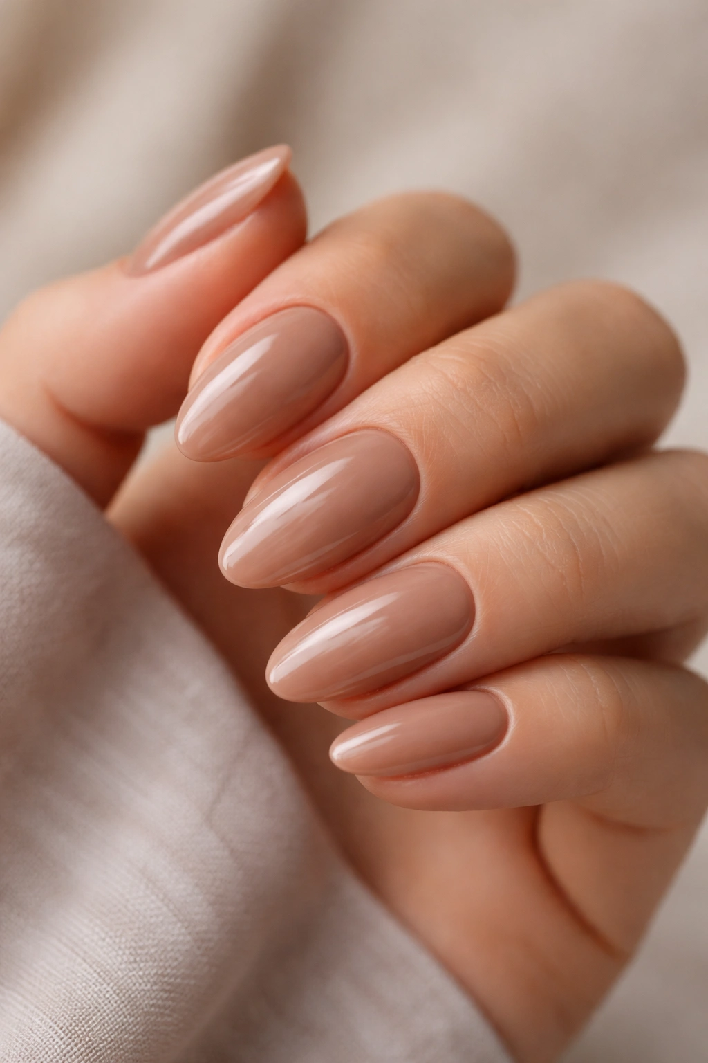 Close-up of mocha nude short almond nails with glossy finish