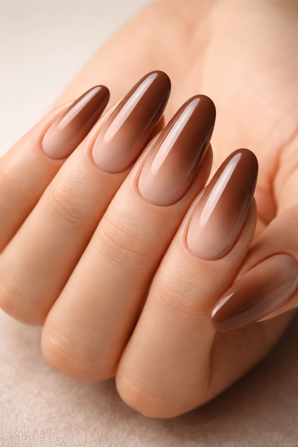 Long oval nails with mocha to nude ombre gradient