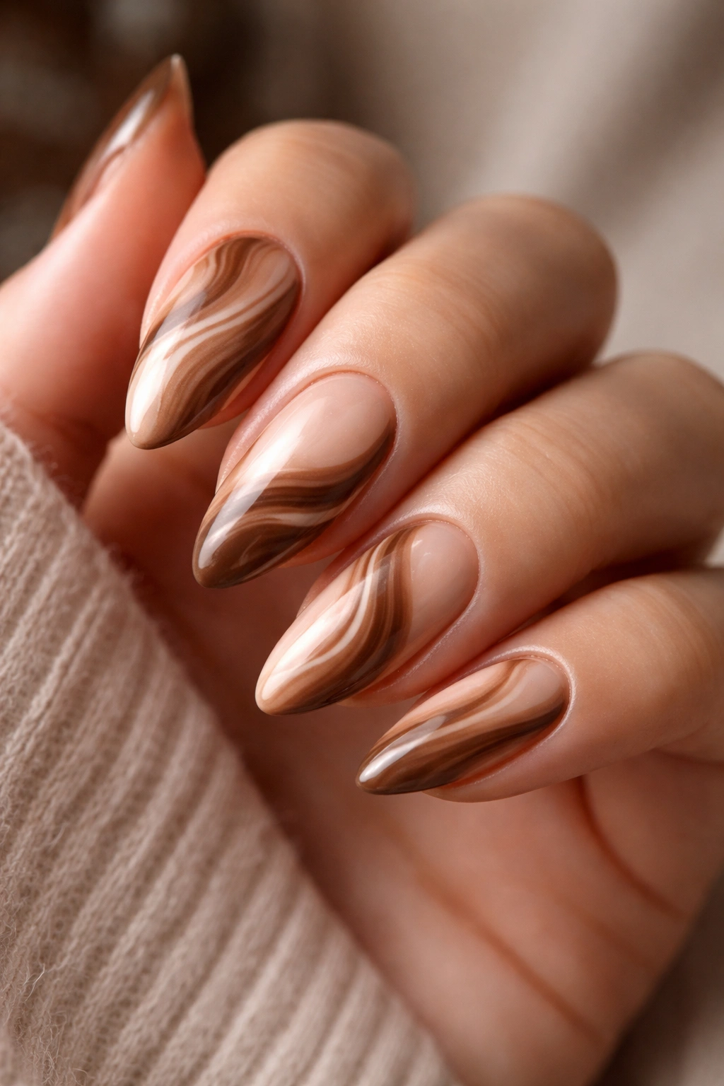Close-up mocha swirl almond nails on nude base