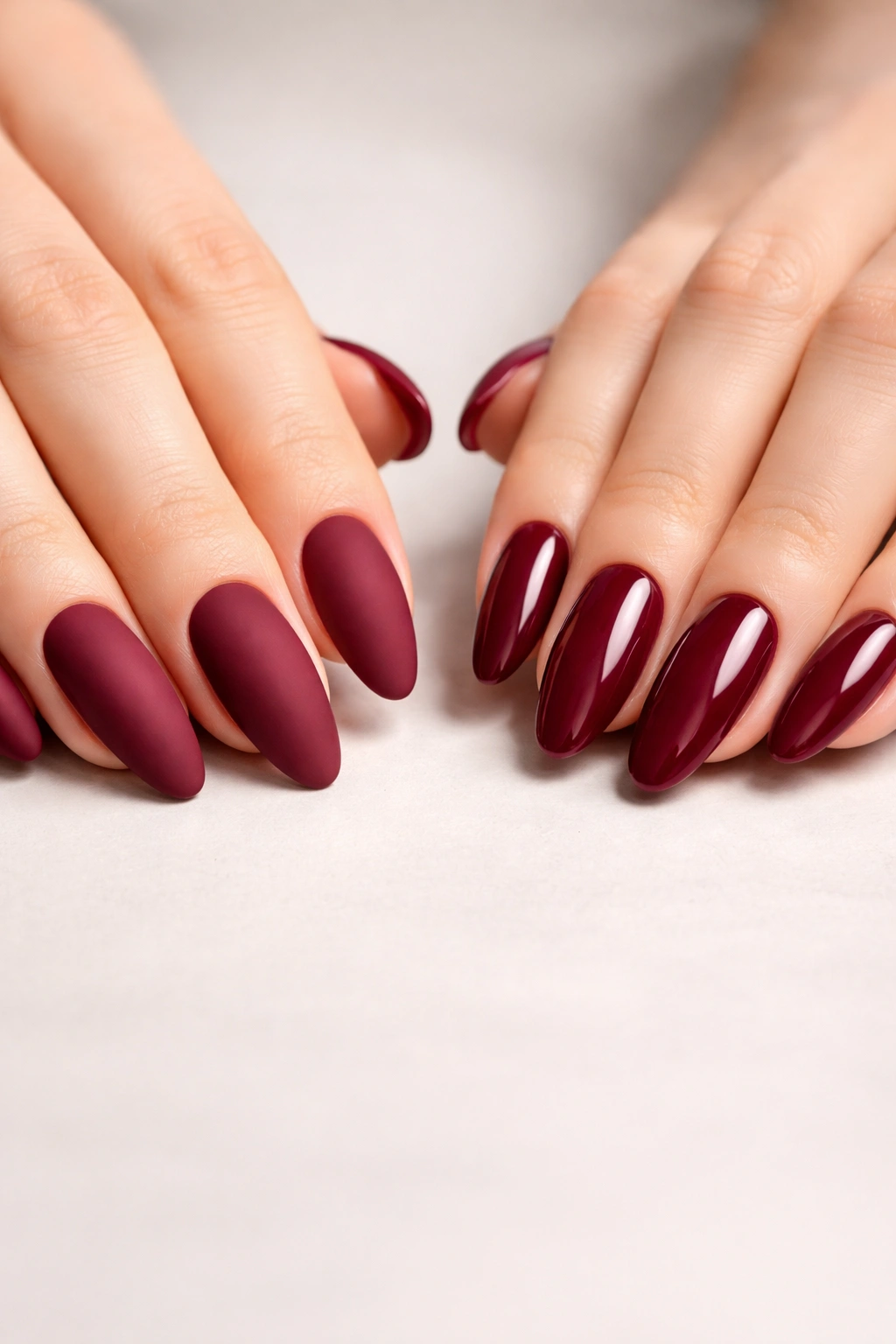 Close-up of two hands with burgundy monochrome nails, one matte and one glossy