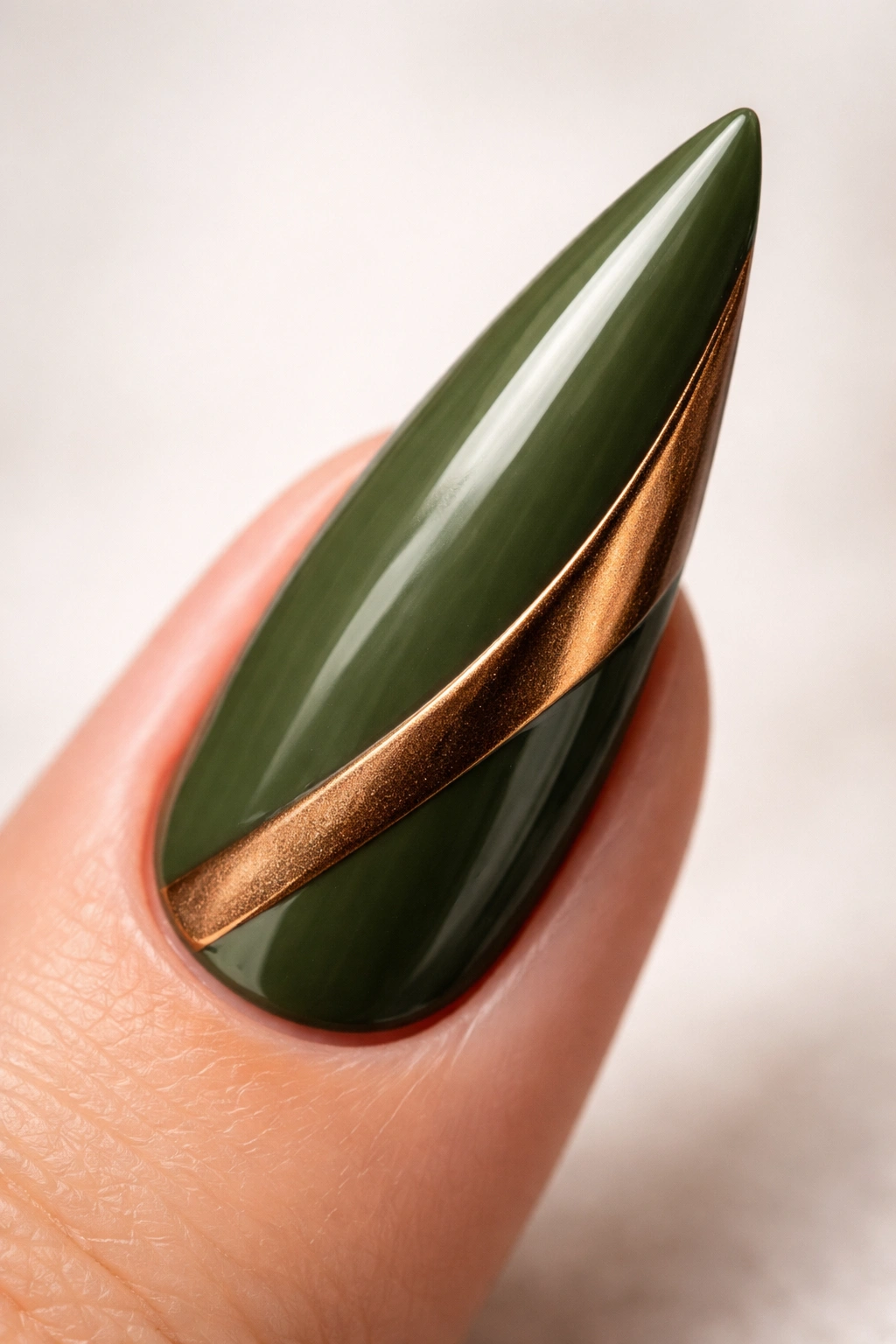 Moss green stiletto nail with bronze metallic accent.