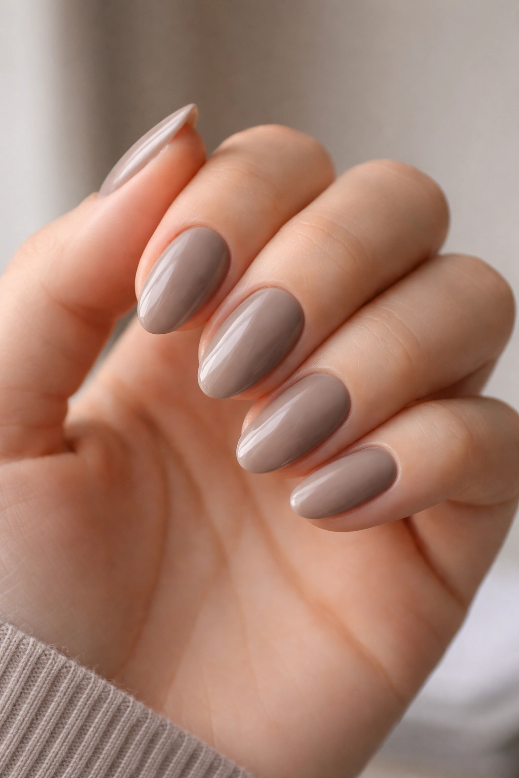 Close-up of mushroom taupe short almond nails with gray-brown undertones