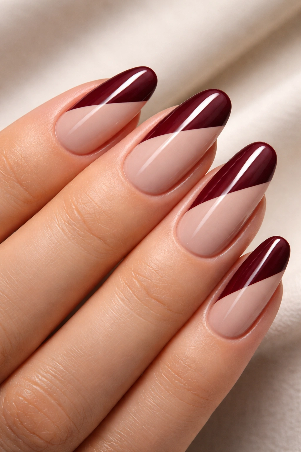 Nails with burgundy diagonal split over nude base