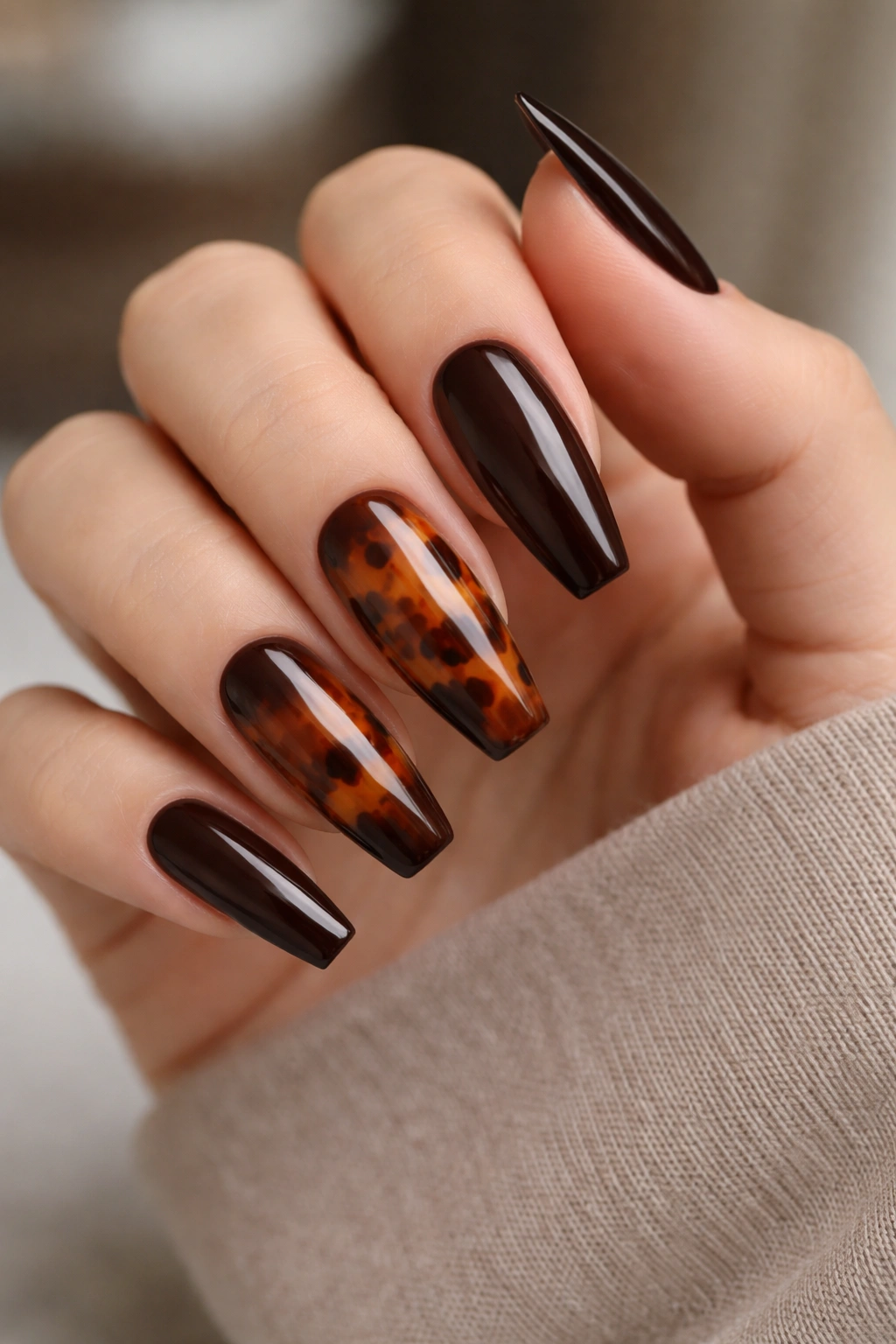 Nails showing espresso and tortoiseshell patterns on a single hand