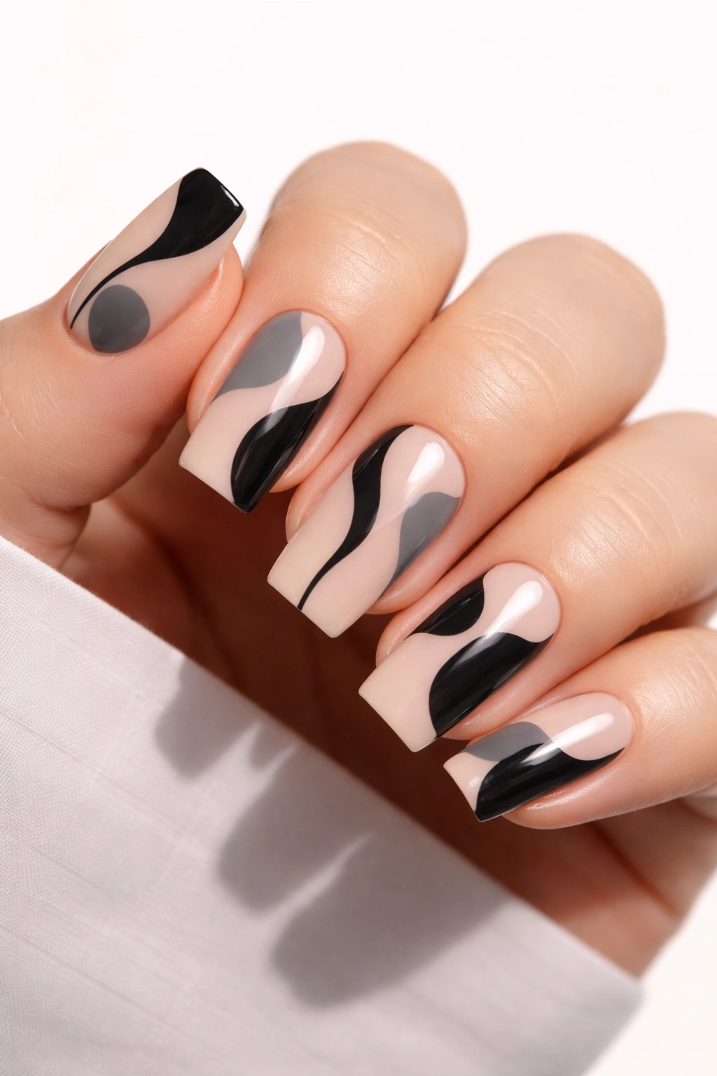 Close-up of soft square nails with black negative space shapes on nude base