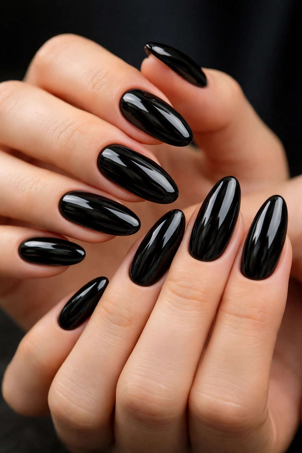 Close-up of glossy black long-oval nails on hands