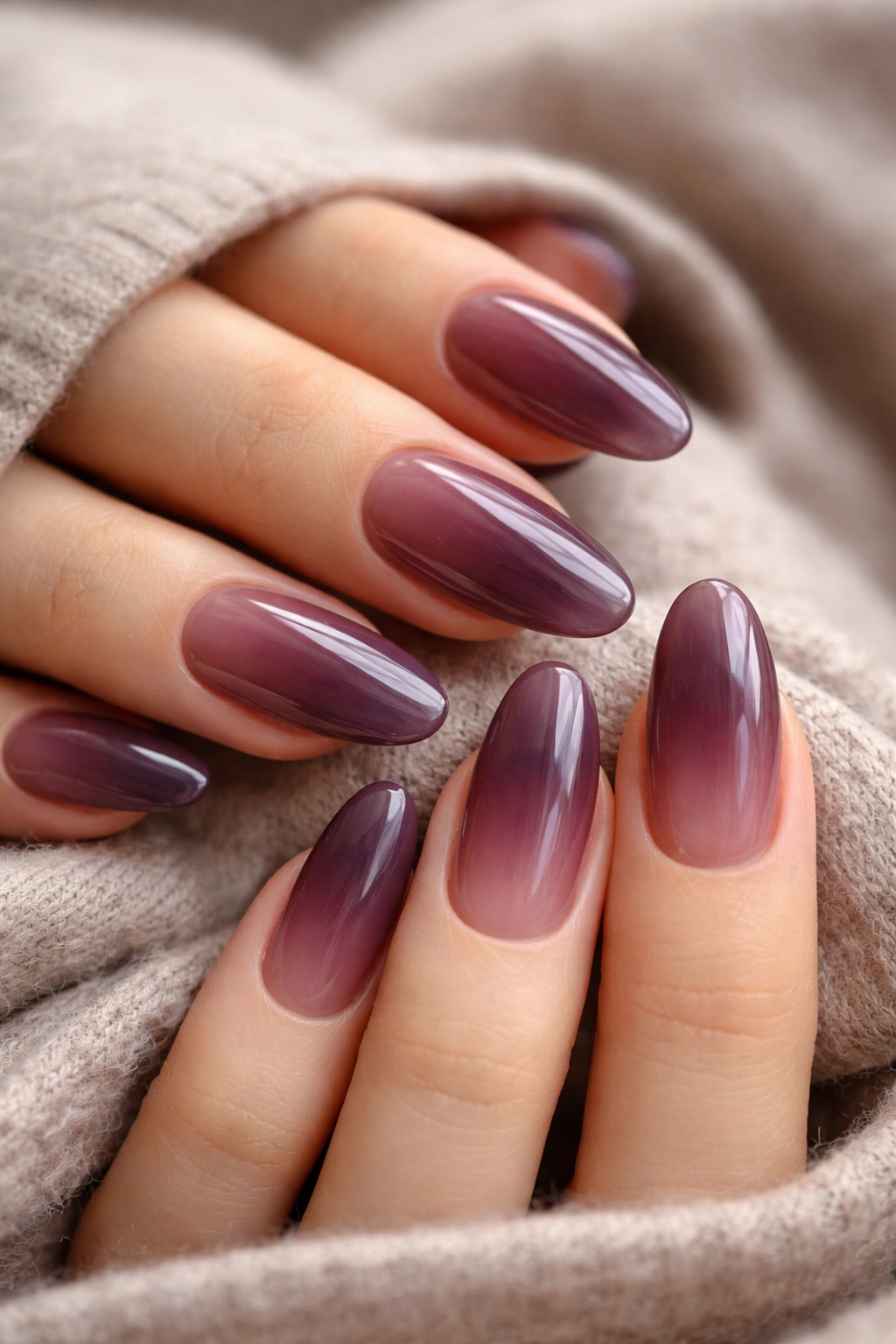 Close-up of smoky plum long-oval nails with sheer depth