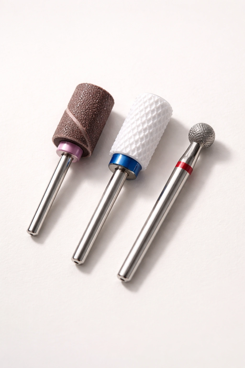 Macro shot of essential nail drill bits on plain background