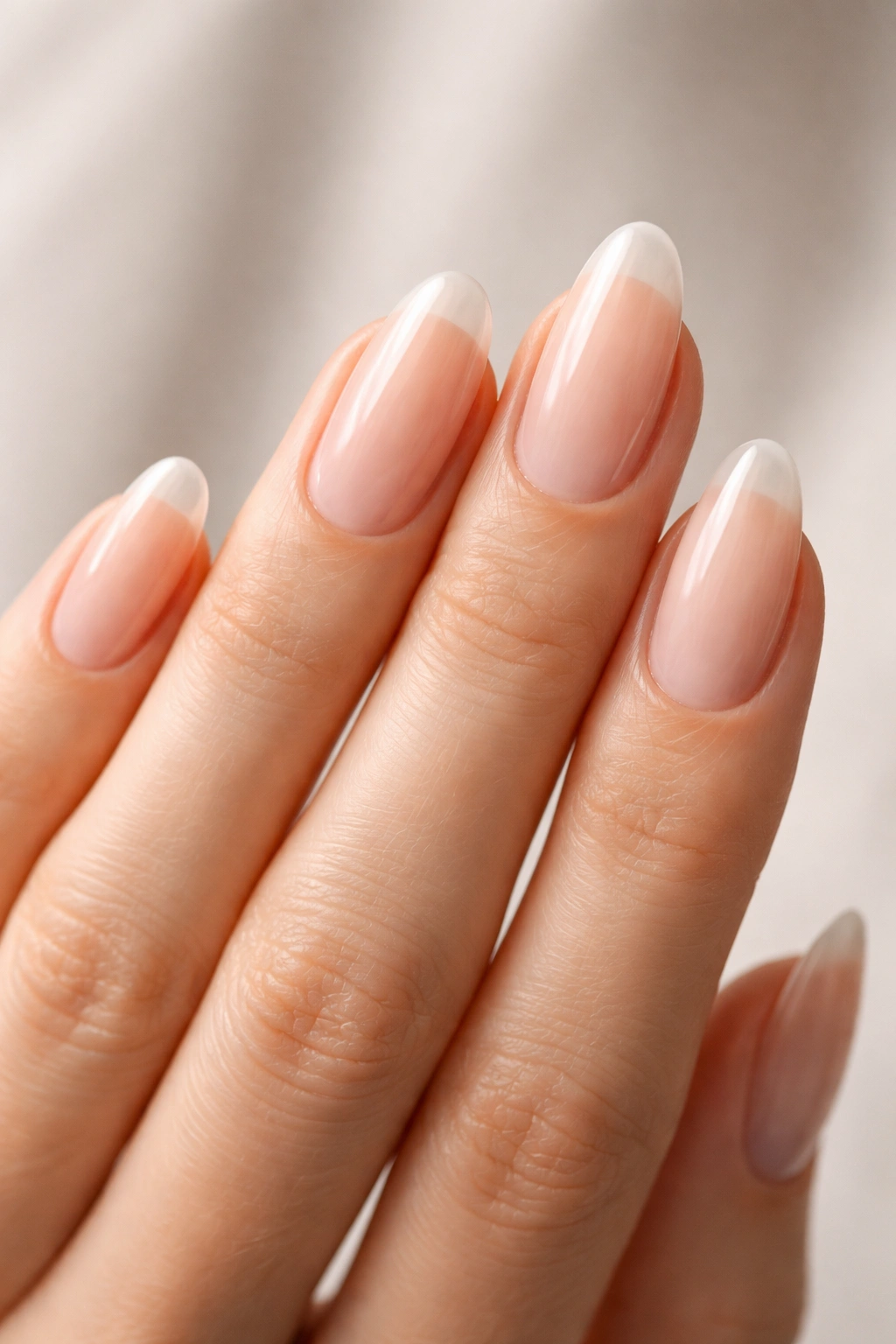 Close-up of natural nails on a hand, emphasizing nail health and shape considerations.
