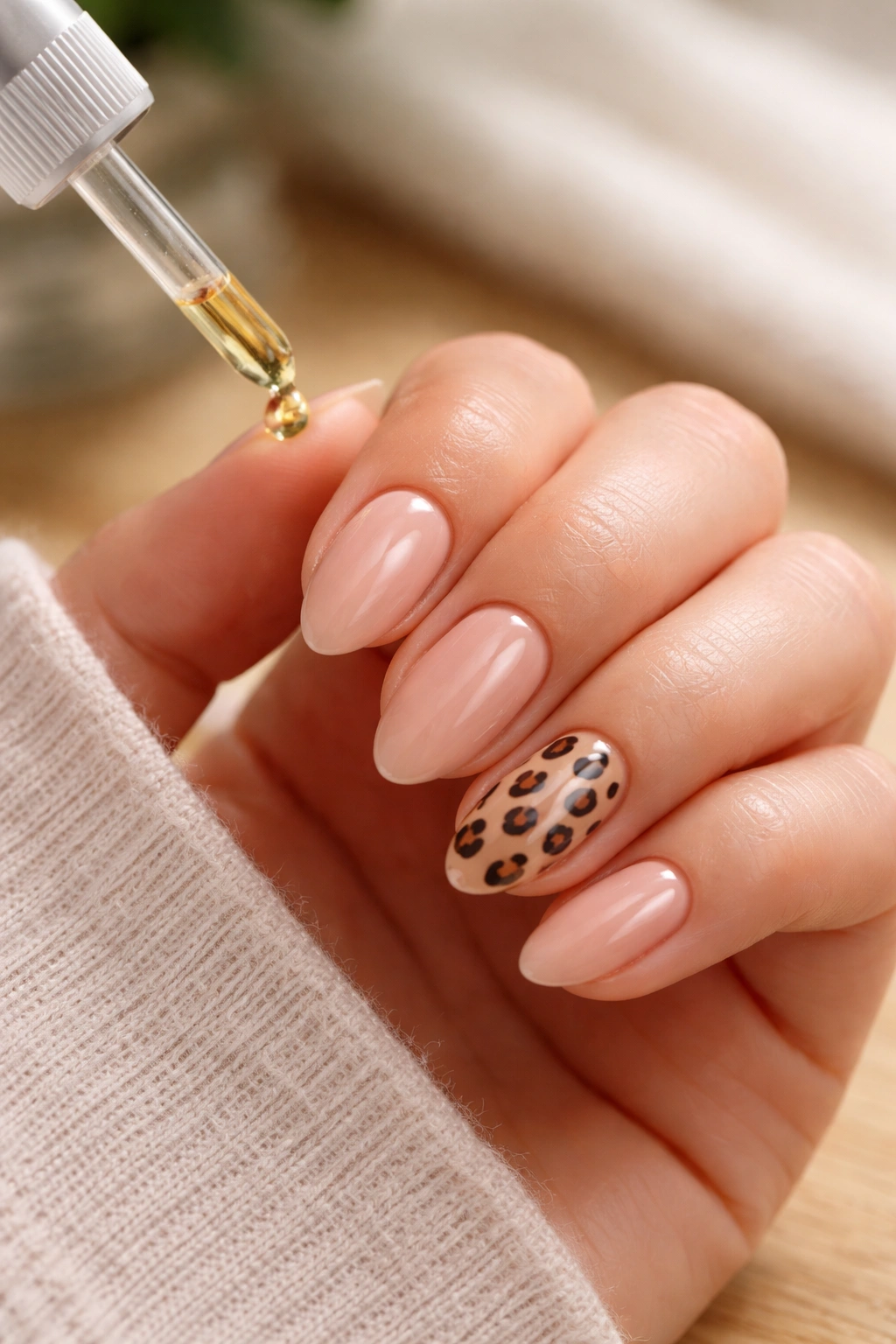 Close-up of short almond nails with leopard print accent and glossy finish