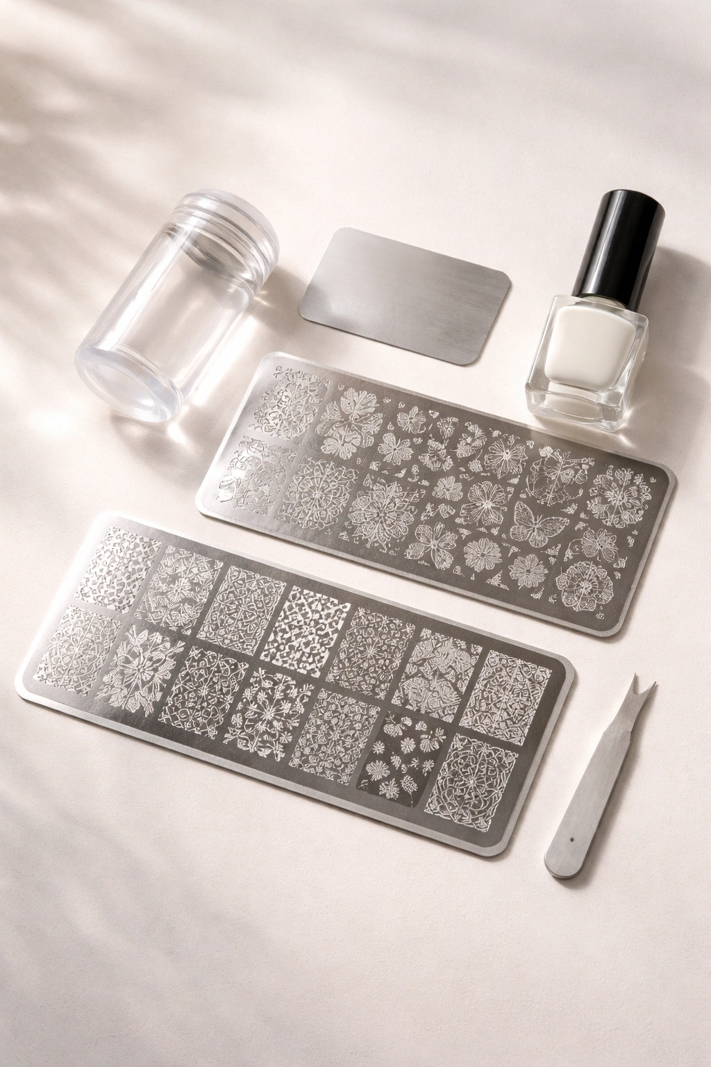 Flat lay of beginner stamping kit with stamping plates, jelly stamper, scraper, and stamping polish