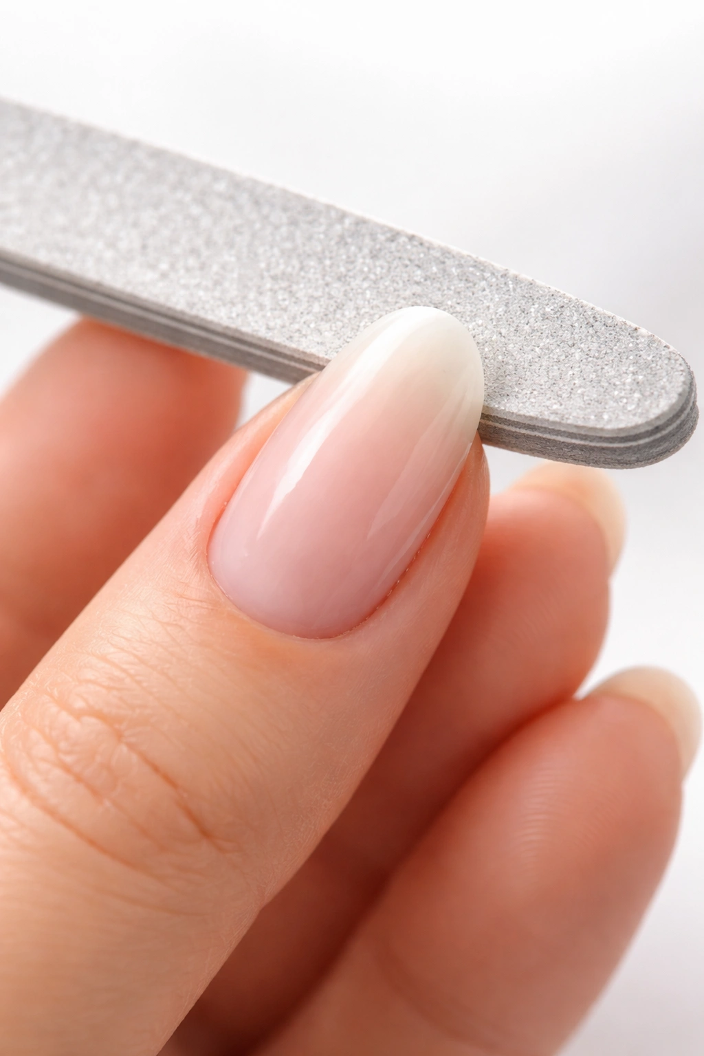 Close-up of nail tip being rounded to form a smooth arch.