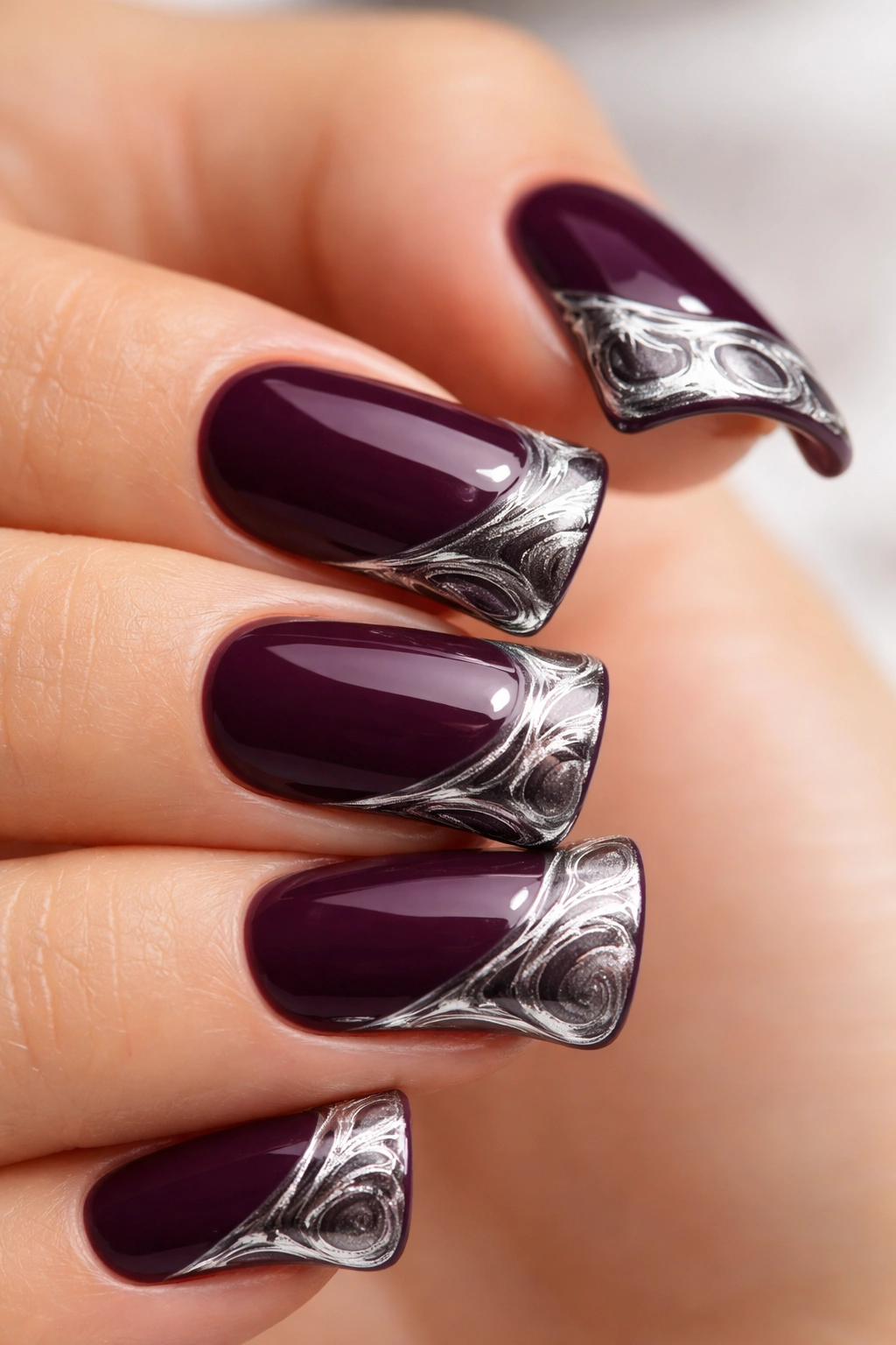 Close-up of deep plum nail with silver marbled duck tip