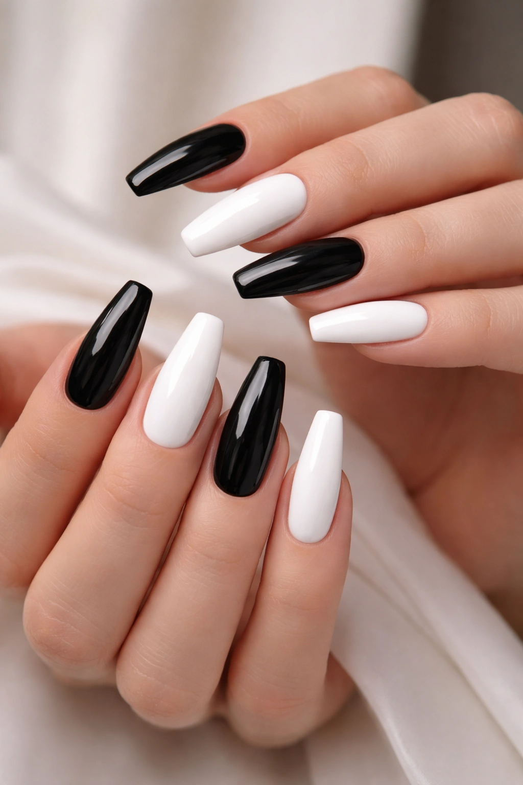 Close-up of hands showing alternating black and white ballerina nails with matching shape