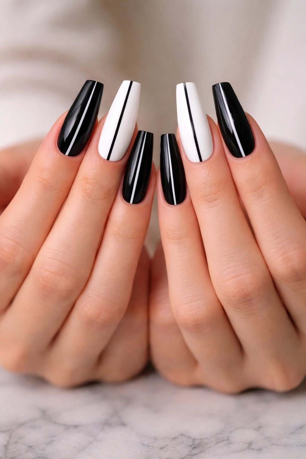 Close-up of center-split nails with a straight vertical line on black and white halves
