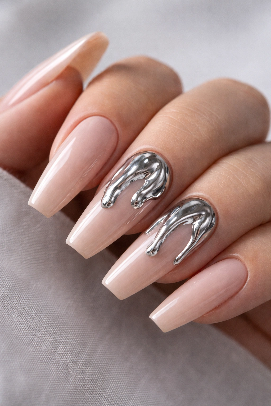 3D chrome drip accents on two ballerina nails on nude base