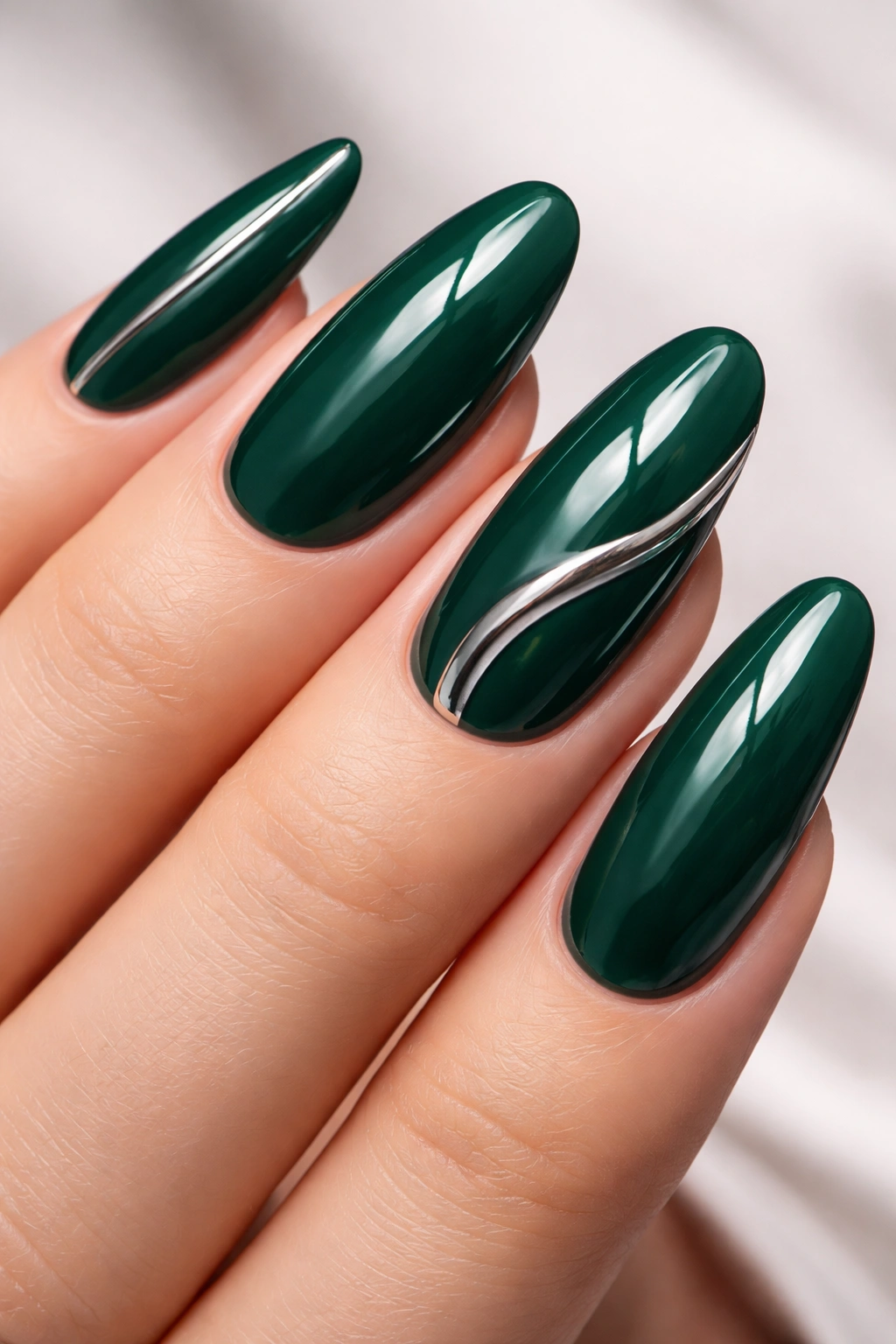 Close-up of deep emerald nails with chrome accents.