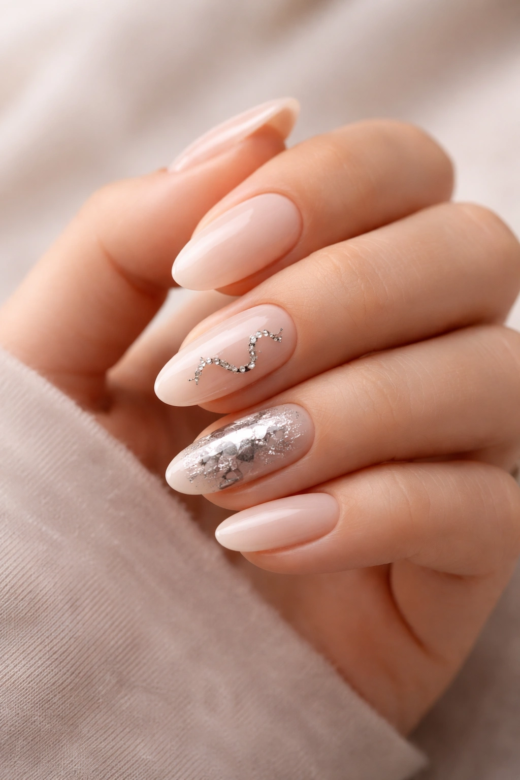 Close-up of hand with nude nails featuring subtle snake accents for versatile wear